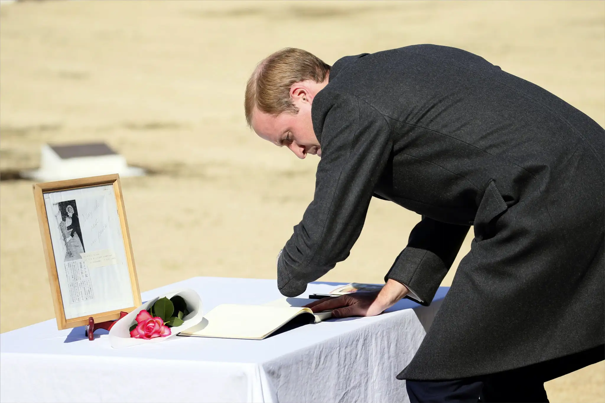 Princ William sa podpisuje do kondolenčnej knihy vedľa fotografie matky Diany.