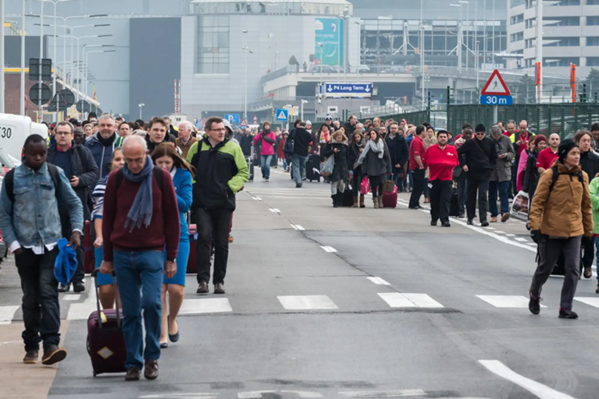Ľudia odchádzajú z bruselského letiska Zaventem po explózii.