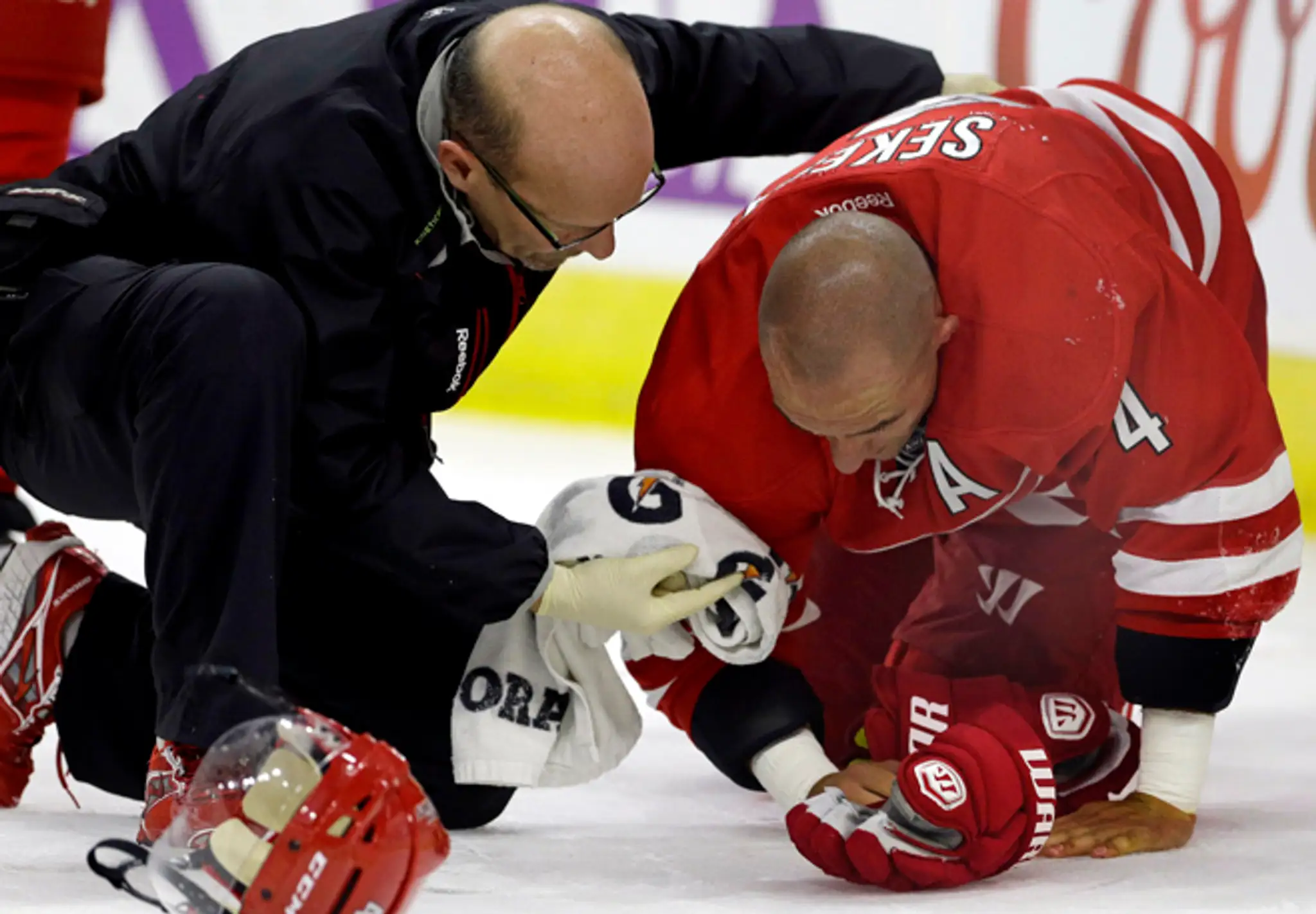 Zranený Andrej Sekera z Caroliny Hurricanes počas ošetrenia v zápase zámorskej NHL proti Buffale Sabres.