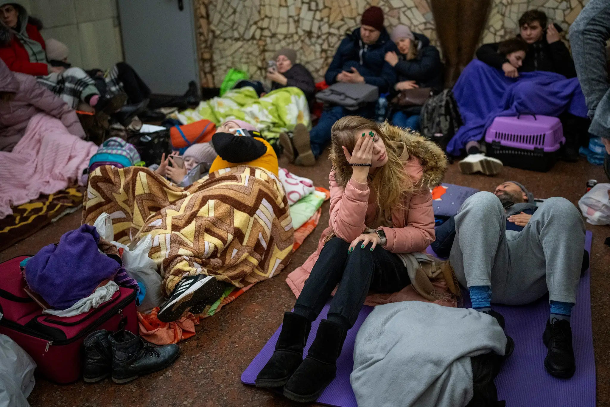Na snímke ľudia odpočívajú v kyjevskom metre, kde sa ukrývajú pred ruskými náletmi