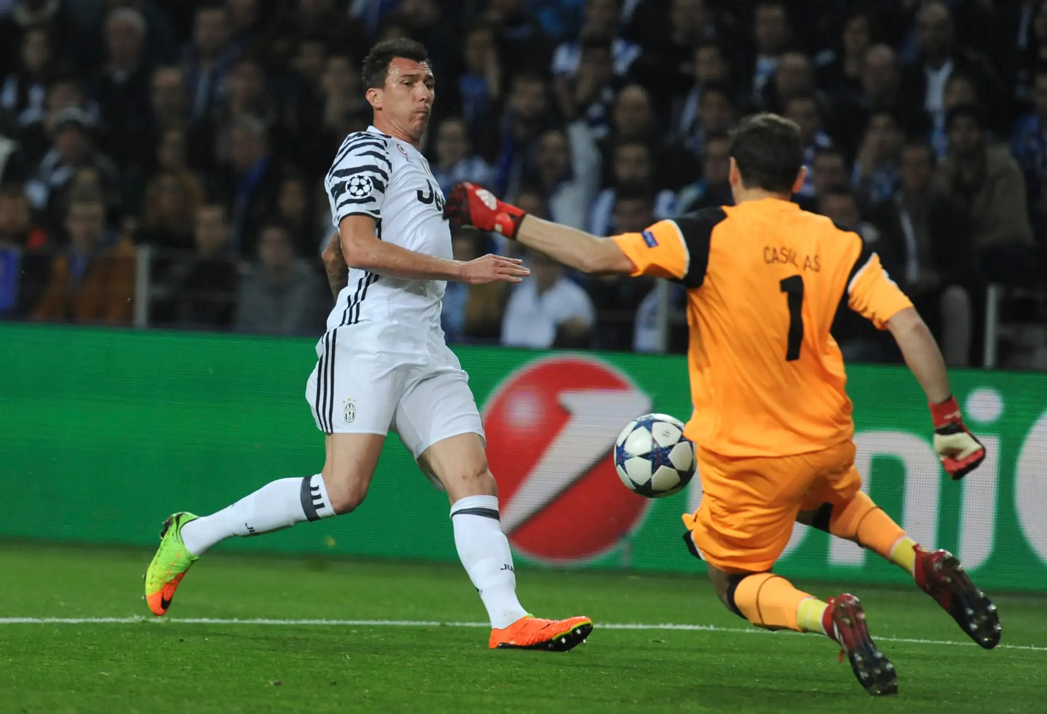 Gólman Porta Iker Casillas čelí v dueli osemfinále LM Mariovi Mandžukičovi z Juventusu.