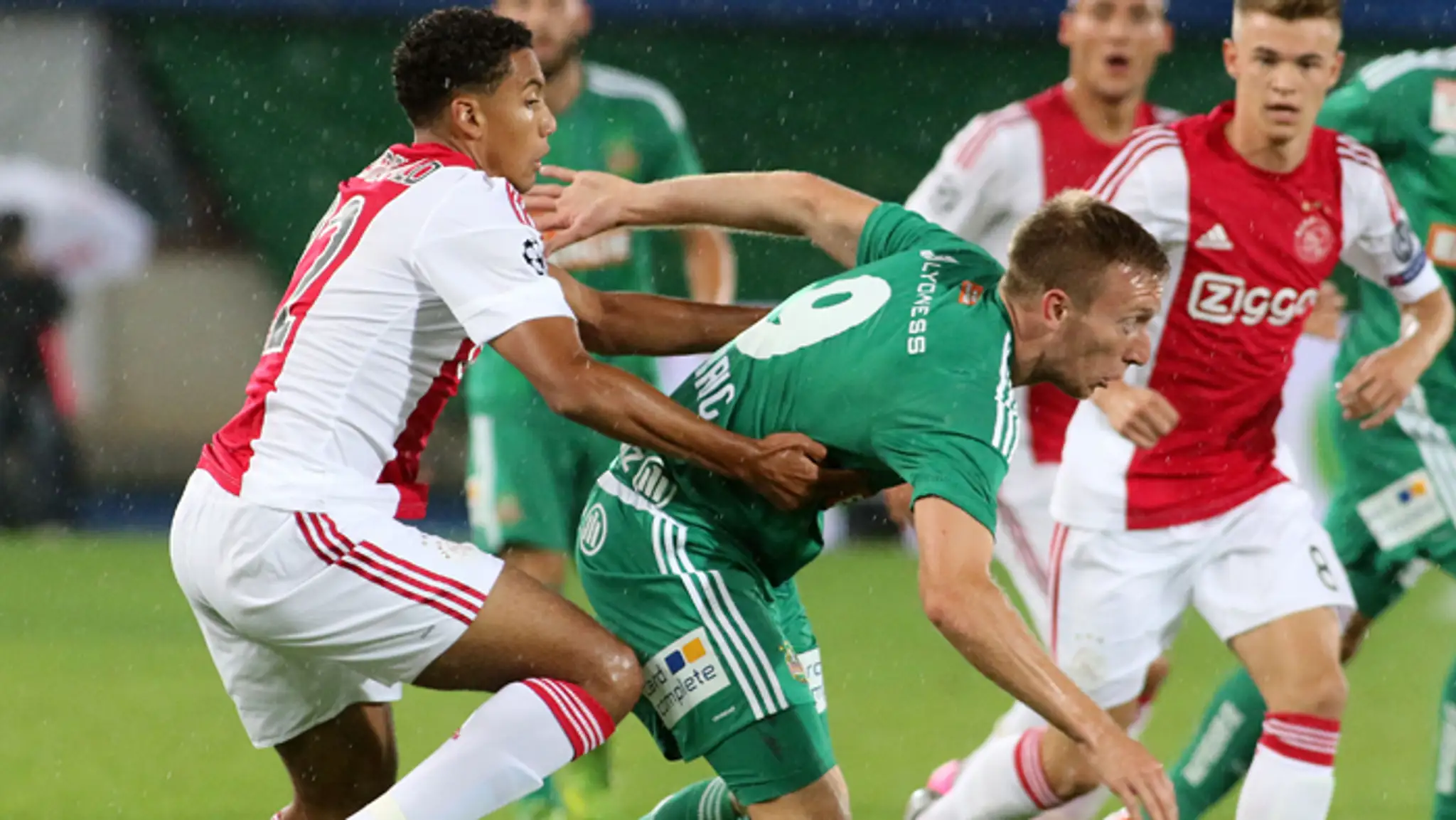 Hráč Ajaxu Jairo Riedewald (vľavo) a Robert Berič (Rapid Viedeň) v predkole Ligy majstrov.