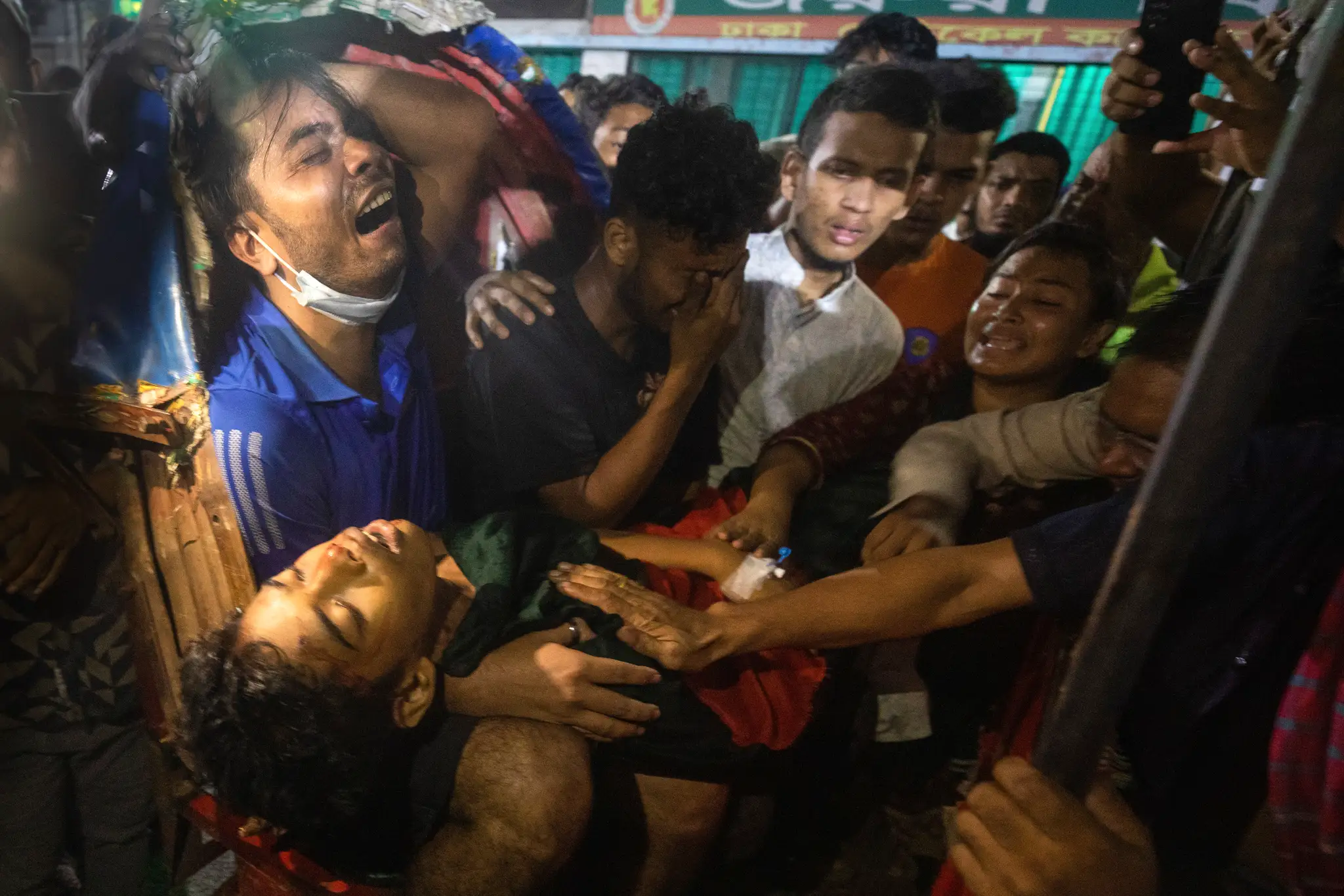 Na snímke muži plačú nad mŕtvym telom muža, ktorý bol zabitý na protivládnych protestoch v Bangladéši.