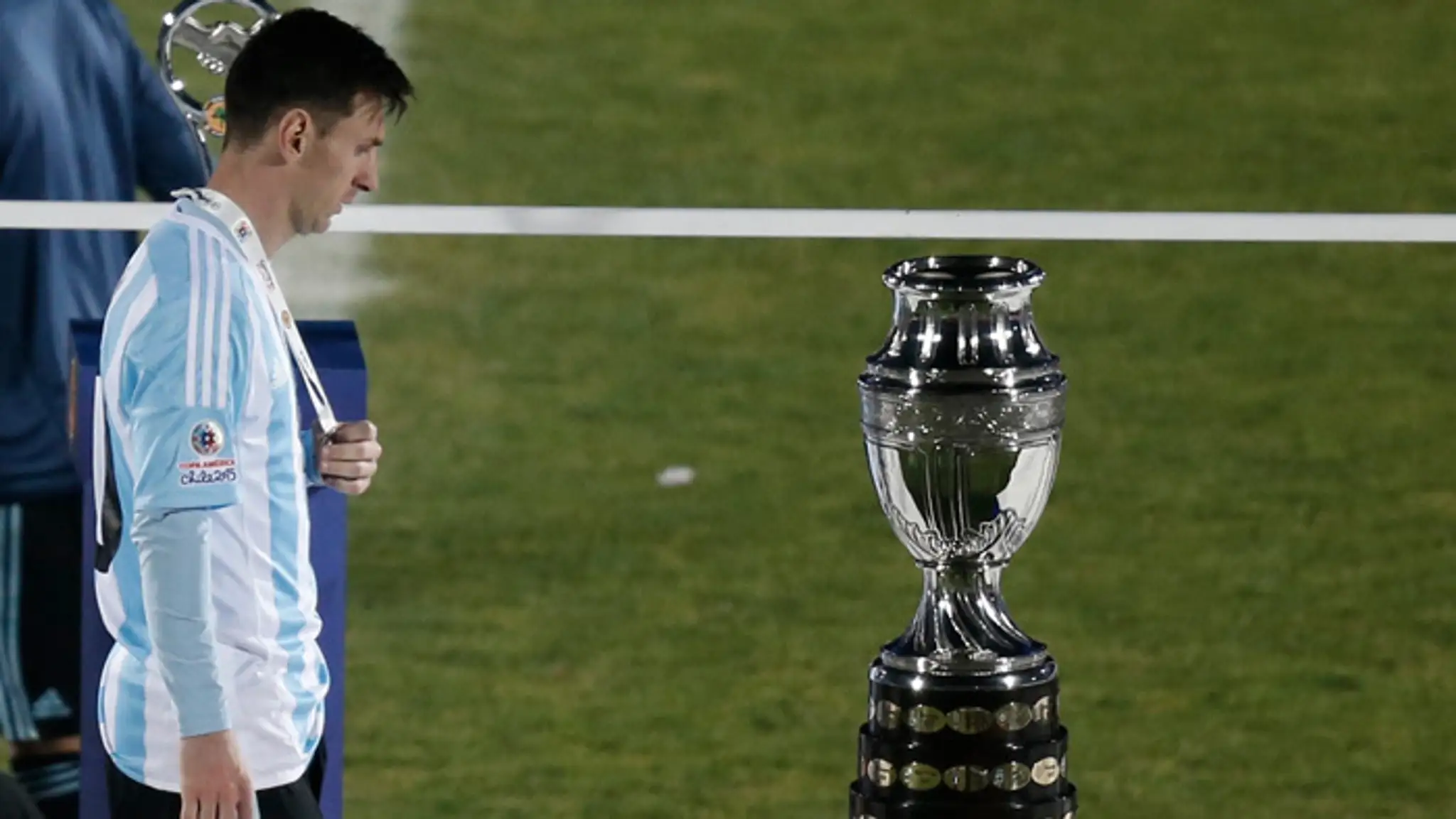 Lionel Messi smutne pozerá na víťaznú trofej Copa America.