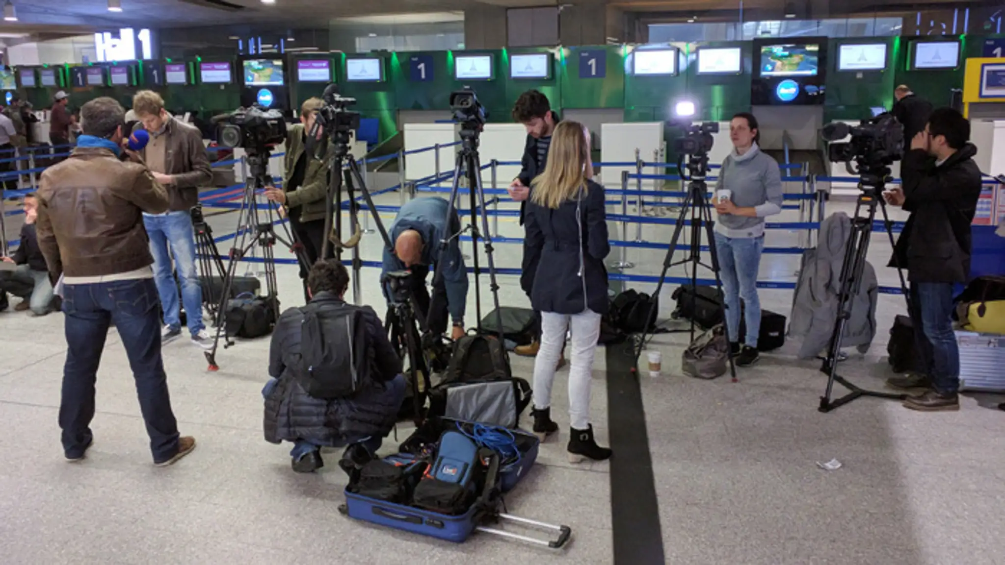Novinári sa zhromažďujú pred pultom leteckej spoločnosti EgyptAir na parížskom Letisku Charlesa de Gaulla.