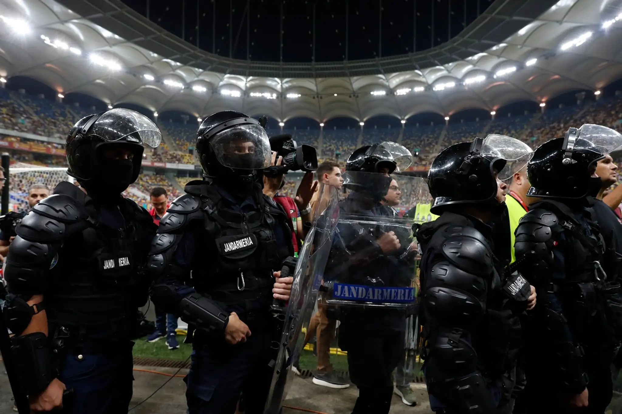 Ťažkoodenci stoja pri tribúne domácich ultras.