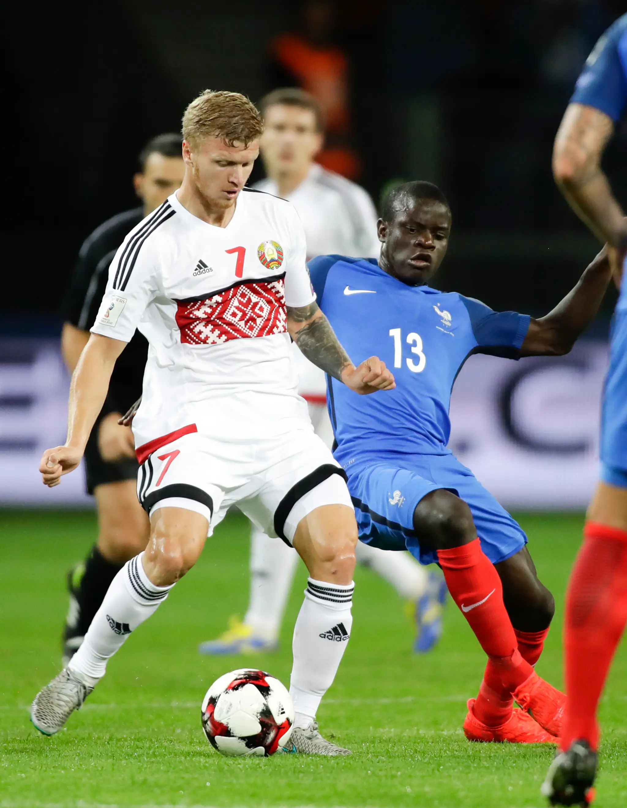Bielorus Nikita Korzun (v bielom) v súbji o loptu s Francúzom N'Golo Kantém v kvalifikácii MS 2018.