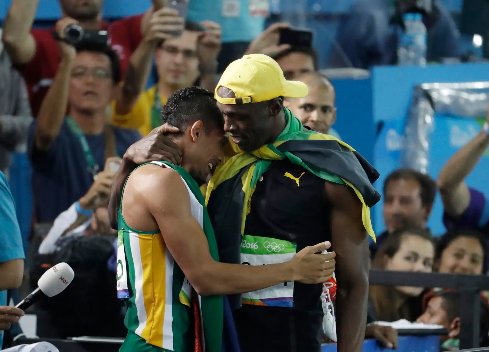 Usain Bolt, víťaz v behu na 100 m, objíma Juhoafričana Waydeho Van Niekerka, nového šampióna v behu na 400 m.