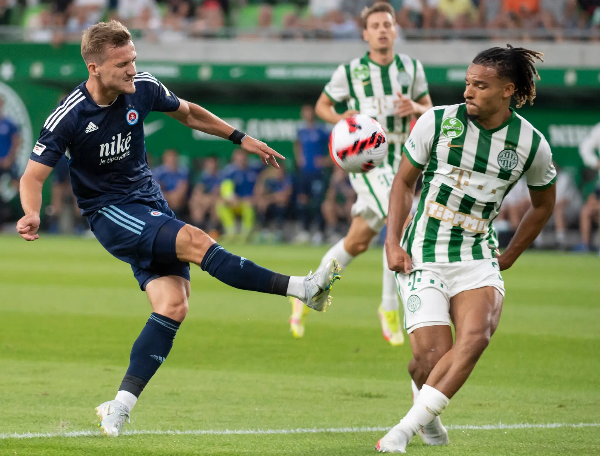 Futbalista Slovana Jurij Medveděv (vľavo) a hráč Ferencvárosu Samy Mmaee bojujú o loptu počas úvodného zápasu 2. predkola LM.