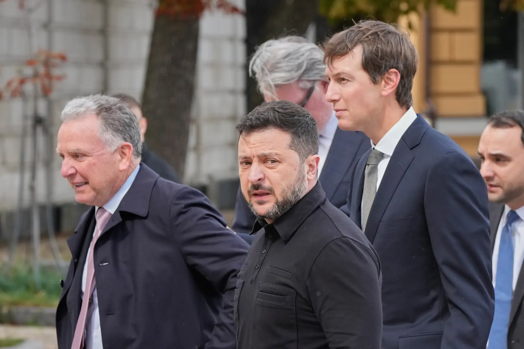 Vyslanci amerického prezidenta Jared Kushner (druhý vpravo) a Steve Witkoff (vľavo) a ukrajinský prezident Volodymyr Zelenskyj (uprosted) kráčajú pred spoločnými rozhovormi v Kyjeve.
