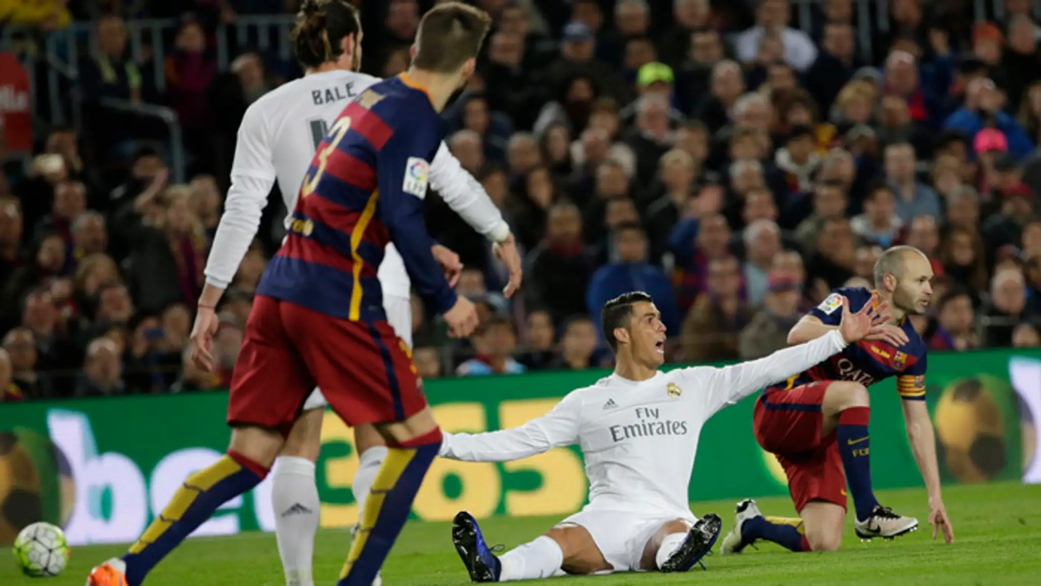 Cristiano Ronaldo gestikuluje počas El Clásico, za ním André Iniesta.