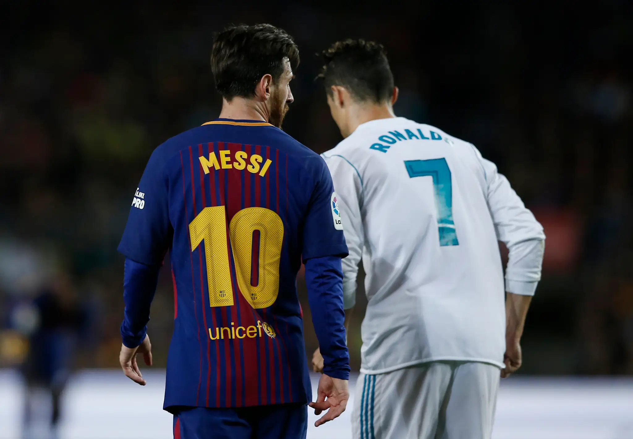 Lionel Messi (vľavo) z Barcelony debatuje s Cristianom Ronaldom z Realu počas vzájomného duelu.