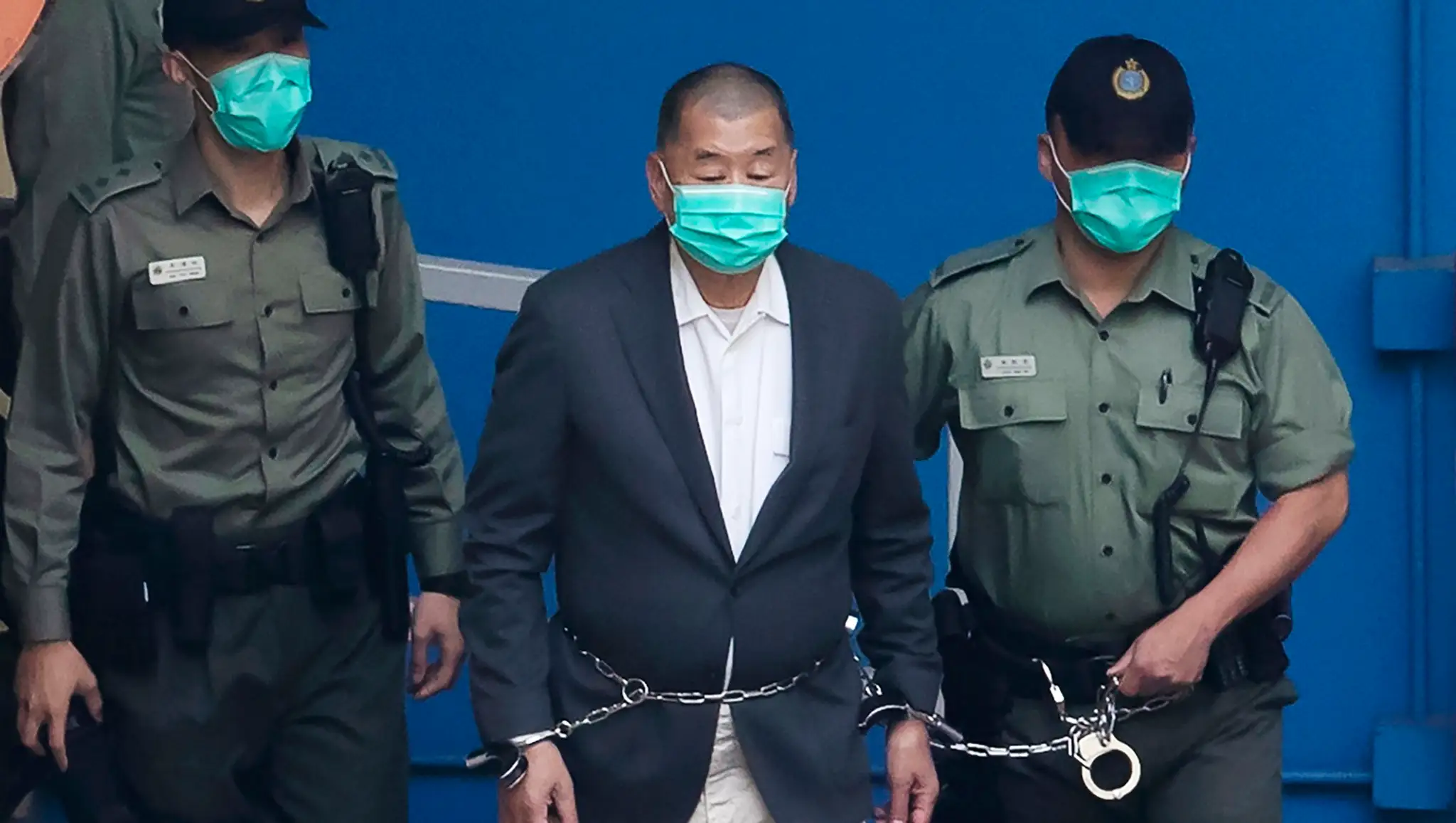Jimmyho Laia privádzajú policajti v putách na súd v Hongkongu.