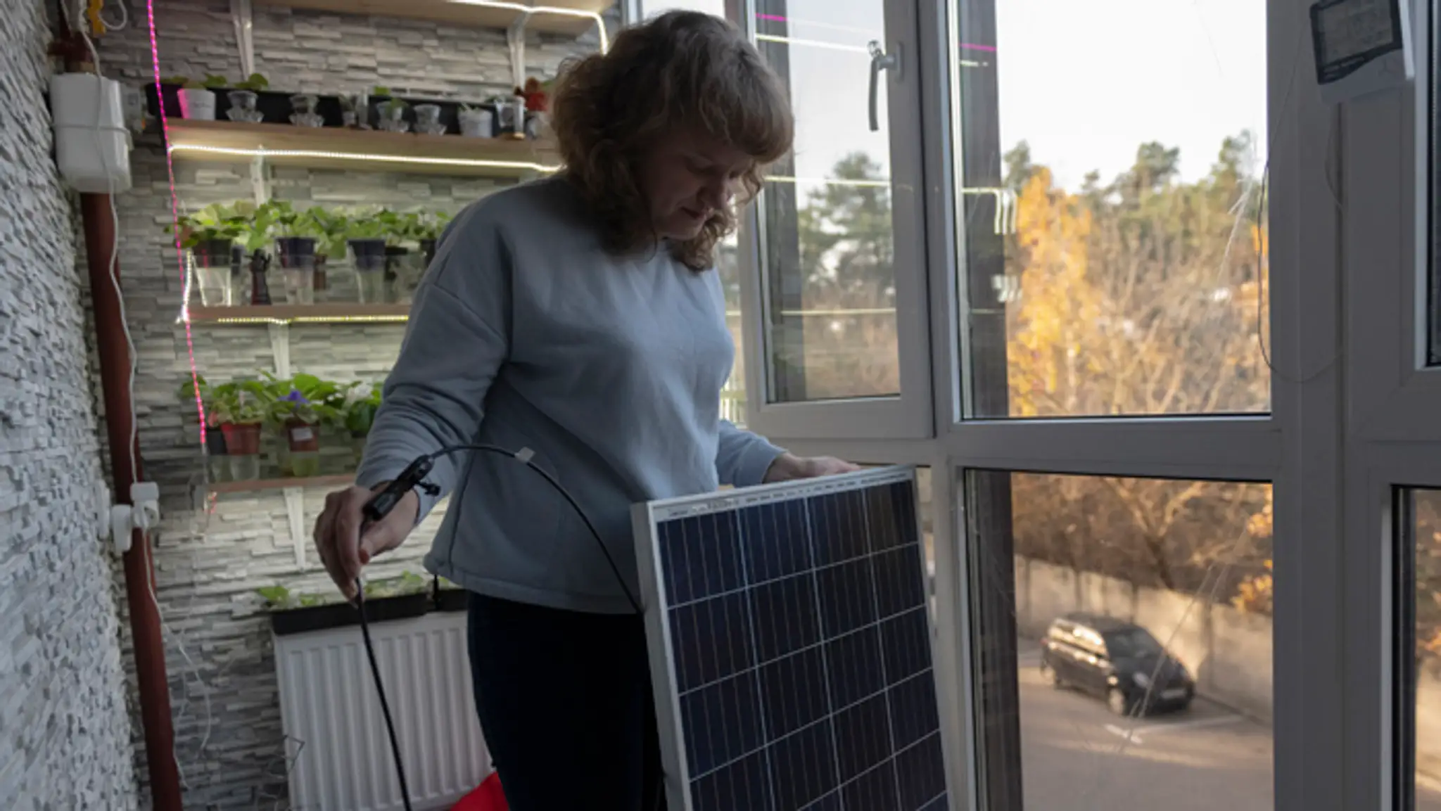 Anna ukazuje solárny panel, ktorý dokáže poskytnúť elektrickú energiu pre celý byt na štyri hodiny v Kyjeve.