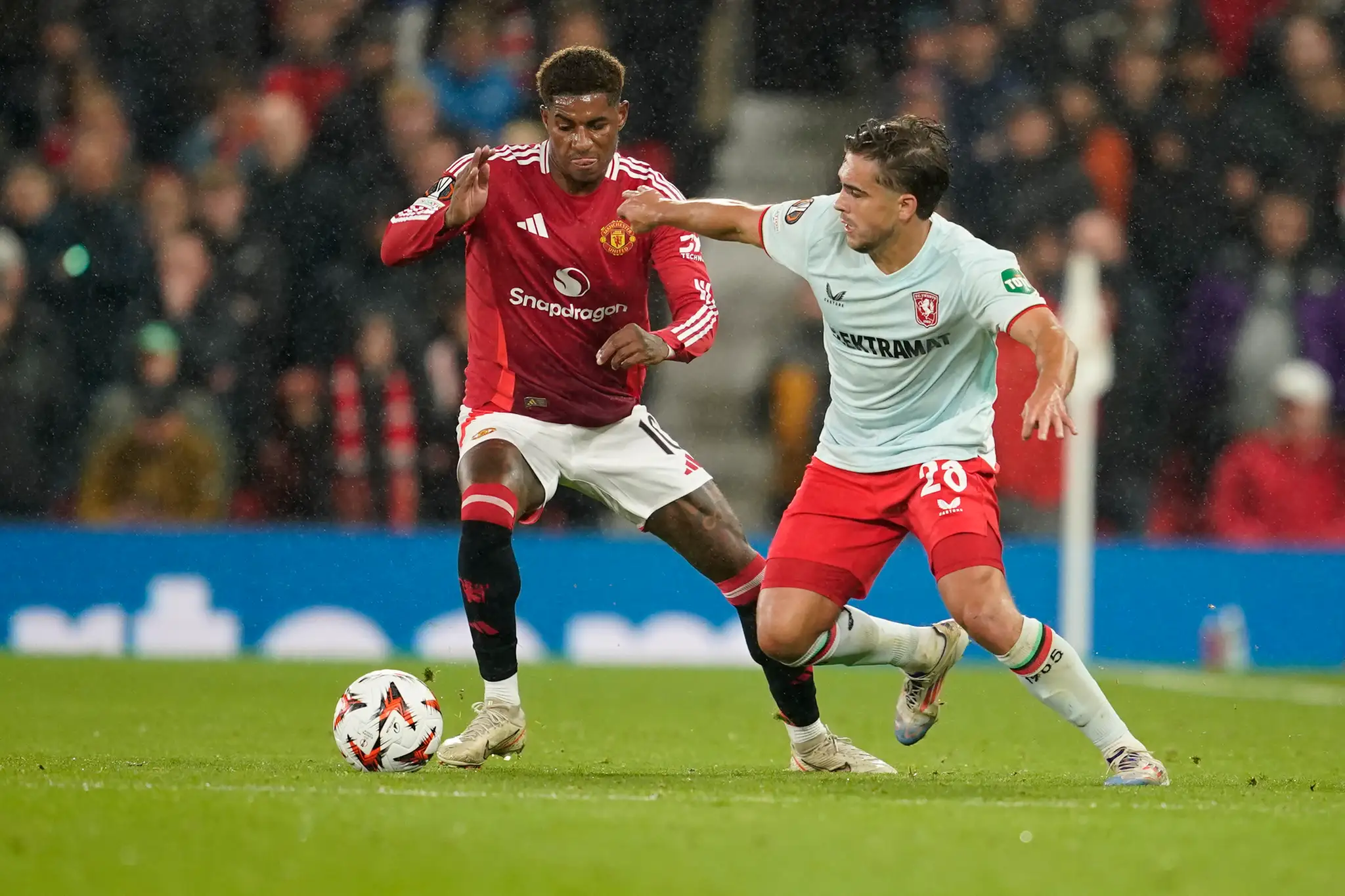 Hráč Manchesteru United Marcus Rashford (vľavo) bojuje o loptu s Bartom van Roojom z Twente