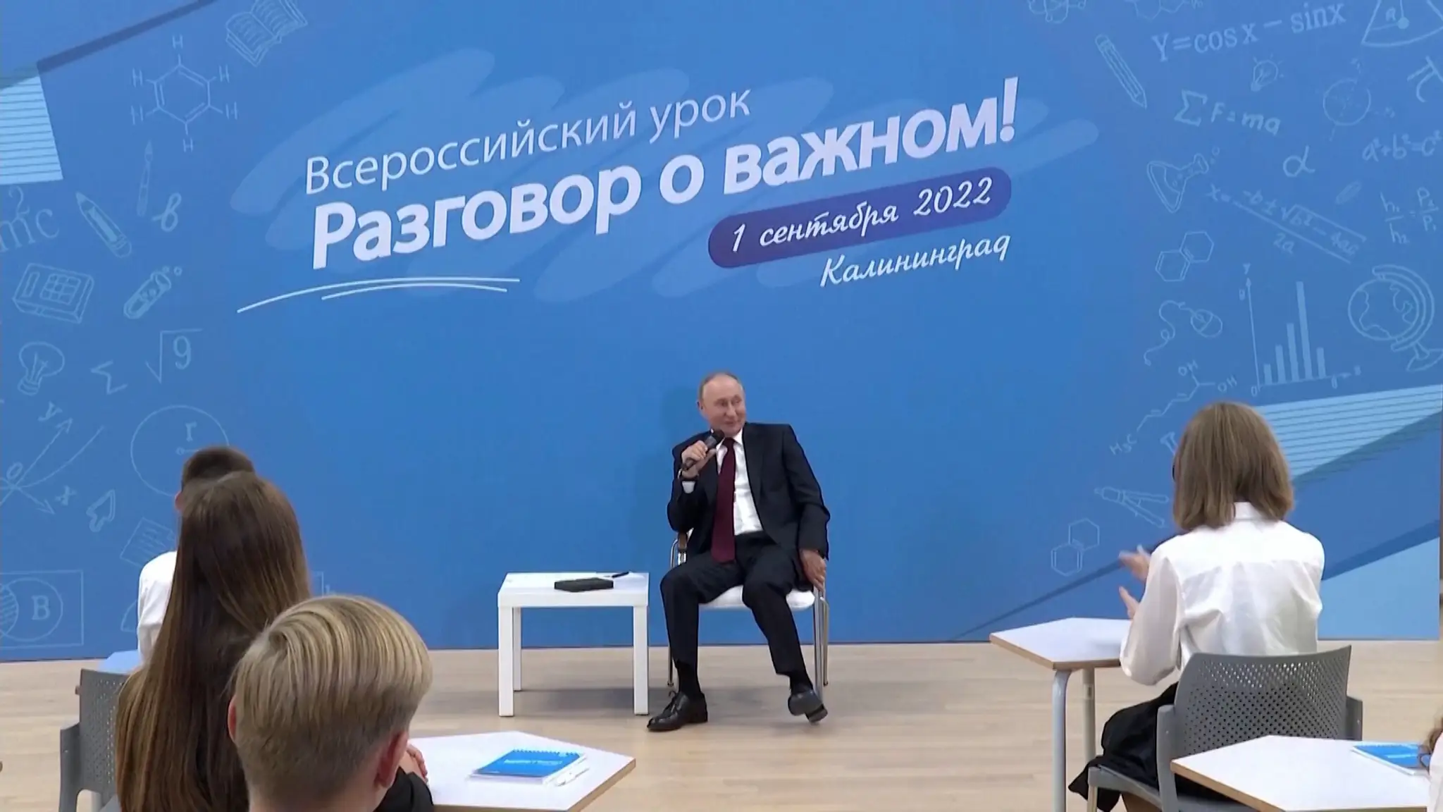 Putin sedí na stoličke.