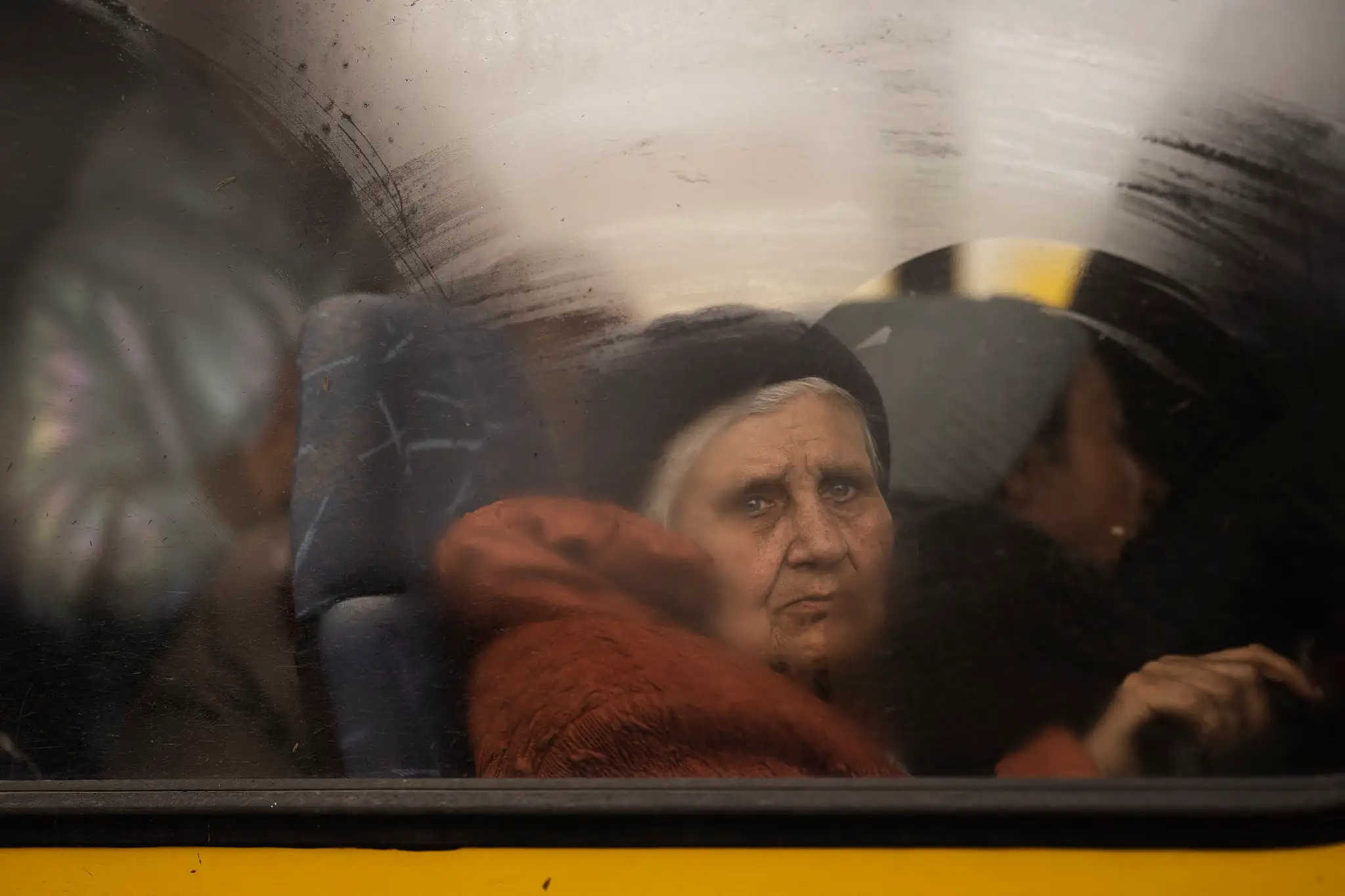 Záber staršej ženy v autobuse v Mariupole.