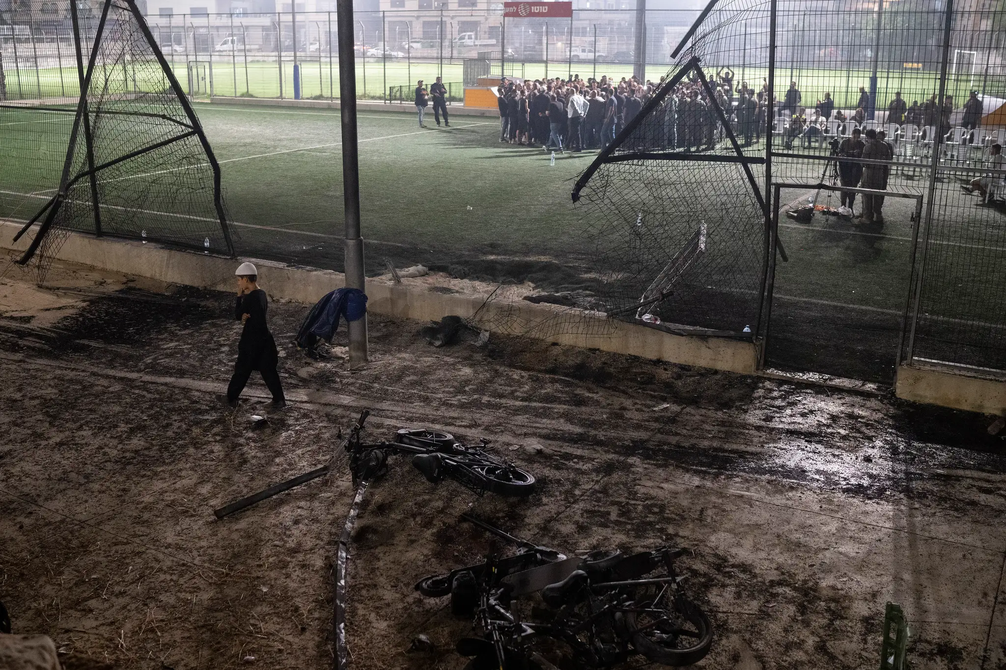 Chlapec kráča okolo bicyklov položených neďaleko futbalového ihriska, ktoré zasiahla raketa v meste Madždal Šams.