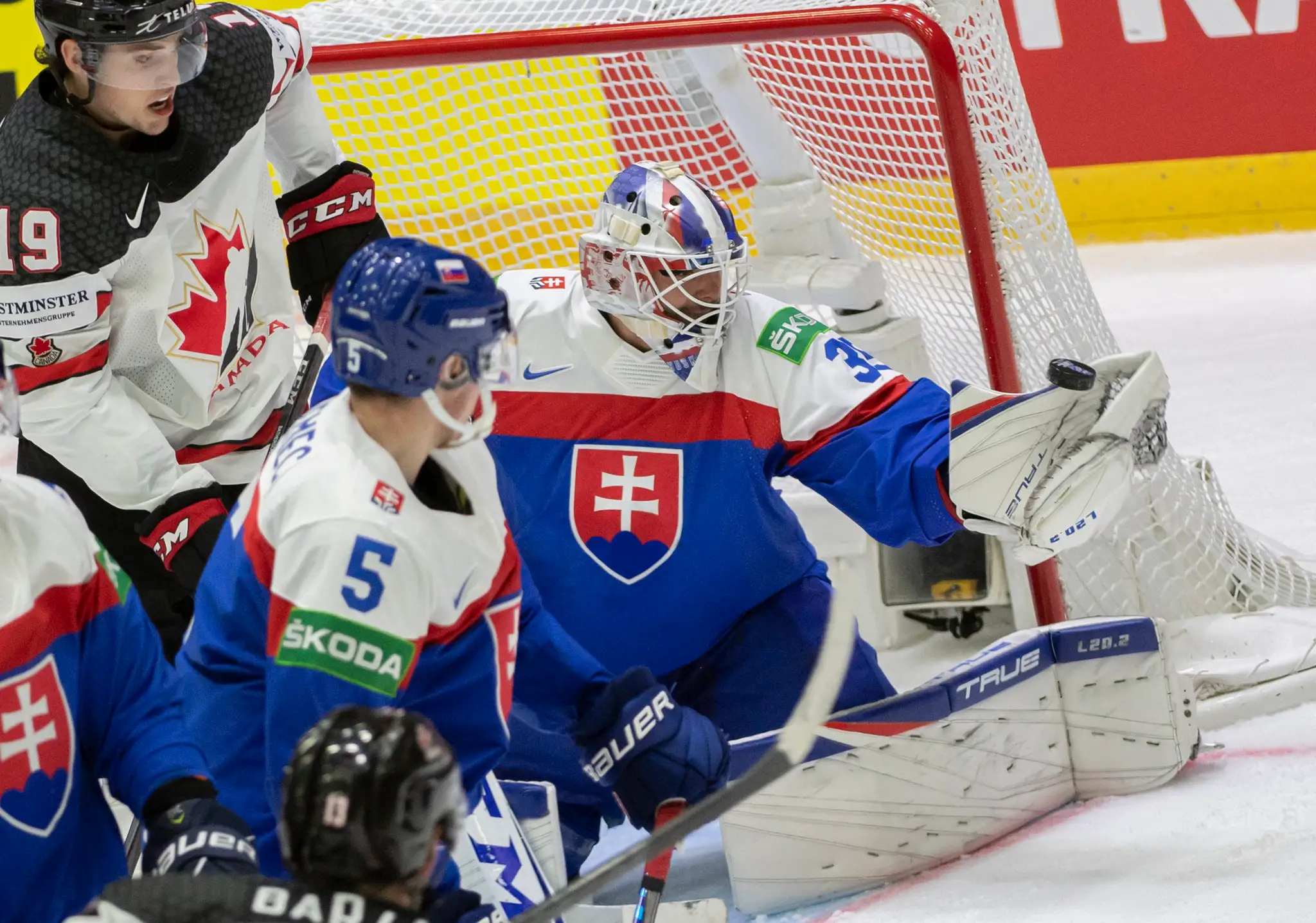 Sprava Adam Húska, uprostred Šimon Nemec (obaja Slovensko) a vľavo Drake Batherson (Kanada) v zápase na MS 2022.