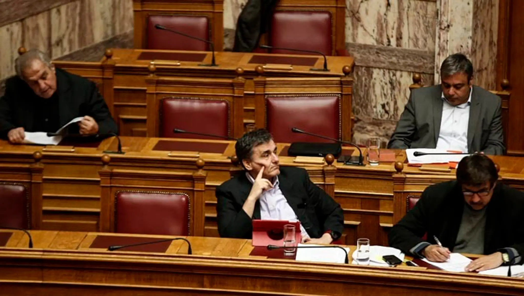 Grécky minister financií Euclid Tsakalotos (v strede) počas zasadnutia parlamentu pred hlasovaním o rozpočte v Aténach.