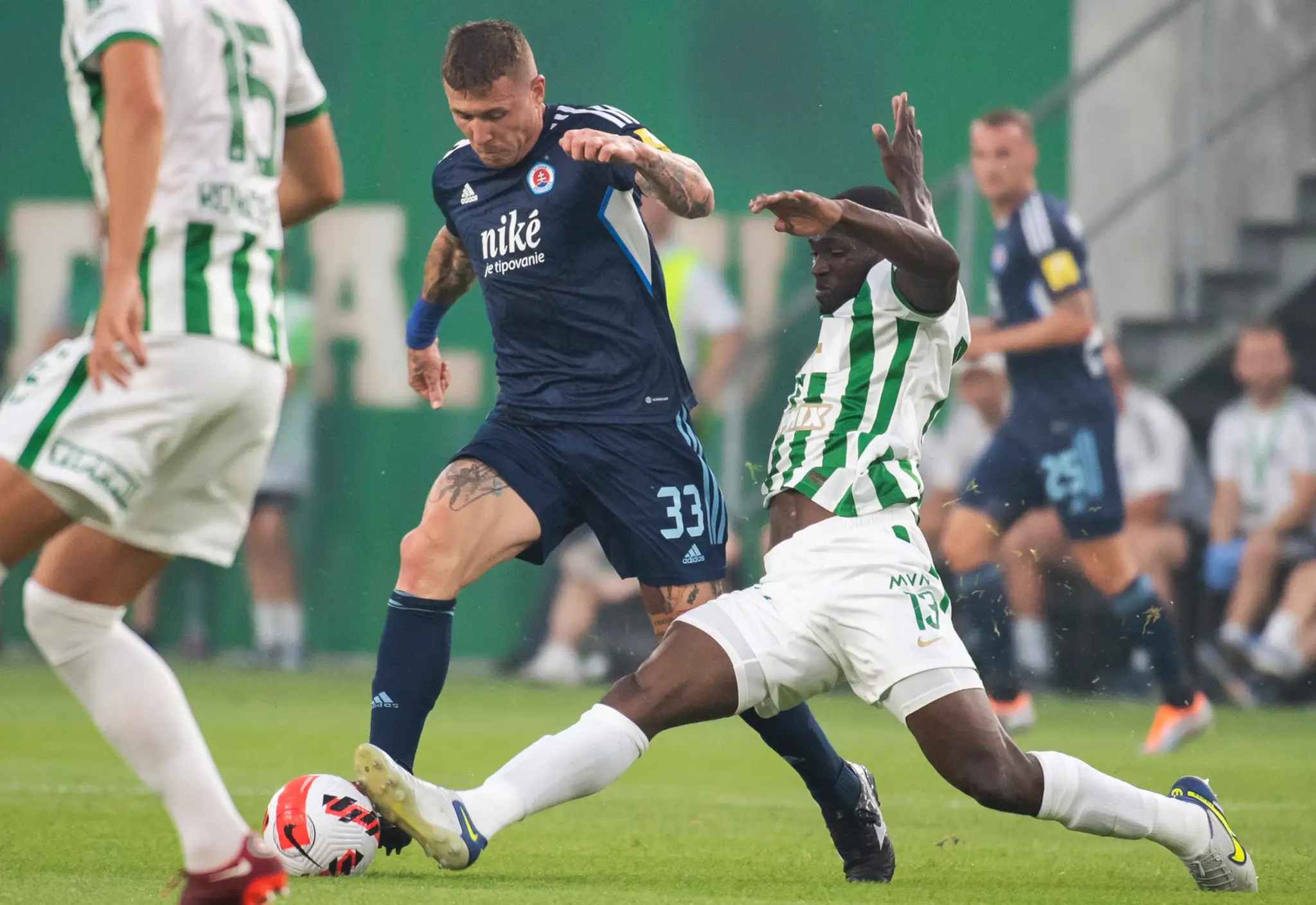 Futbalista Slovana Juraj Kucka (uprostred) a hráč Ferencvárosu Anderson Esiti počas úvodného zápasu 2. predkola LM.