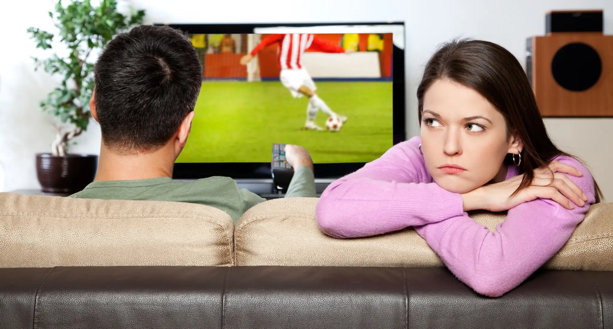 Muž pozerá futbal, žena sa nudí.