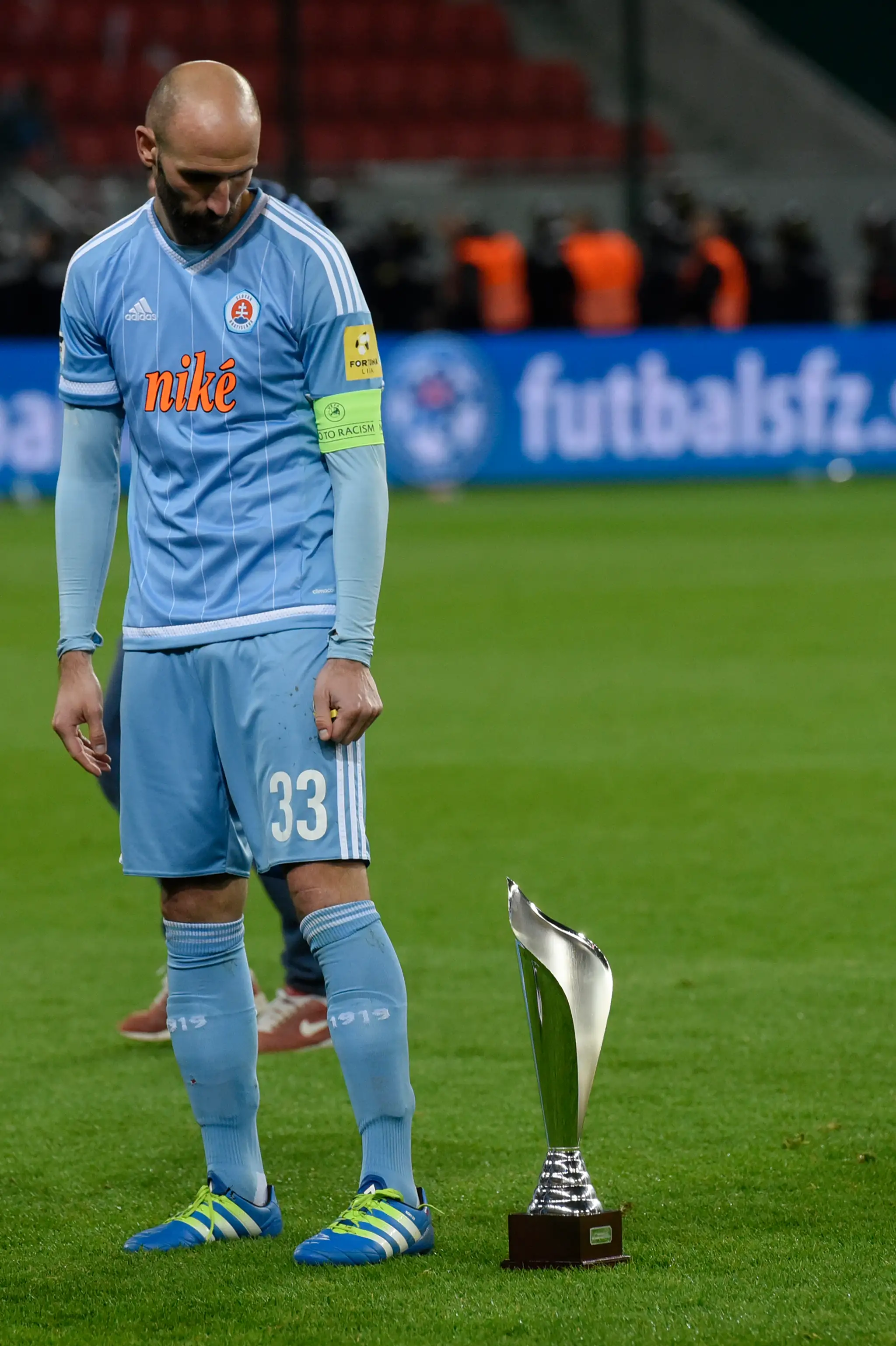 Kapitán ŠK Slovan Róbert Vittek pozerá na pohár slovenského pohárového majstra.
