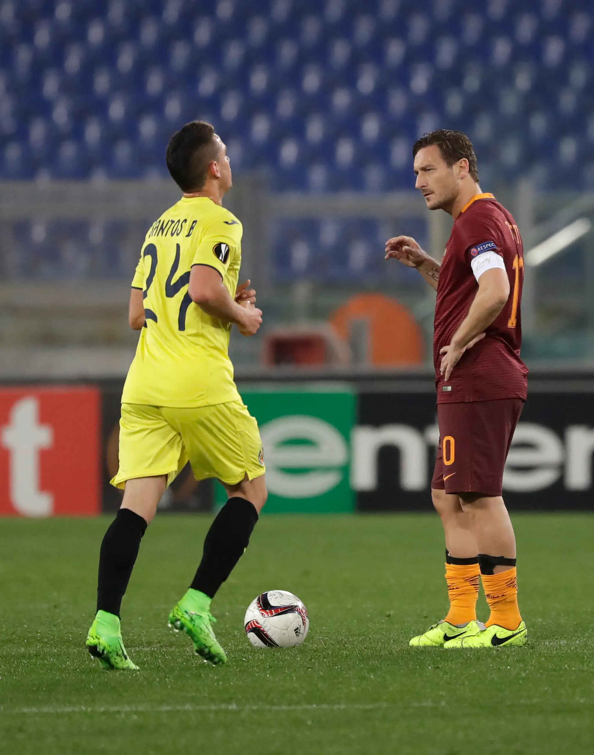 Rafael Borre (vľavo) z Villarrealu beží k stredovému kruhu, pozerá na neho Francesco Totti z Rímu v šestnásťfinále EL.