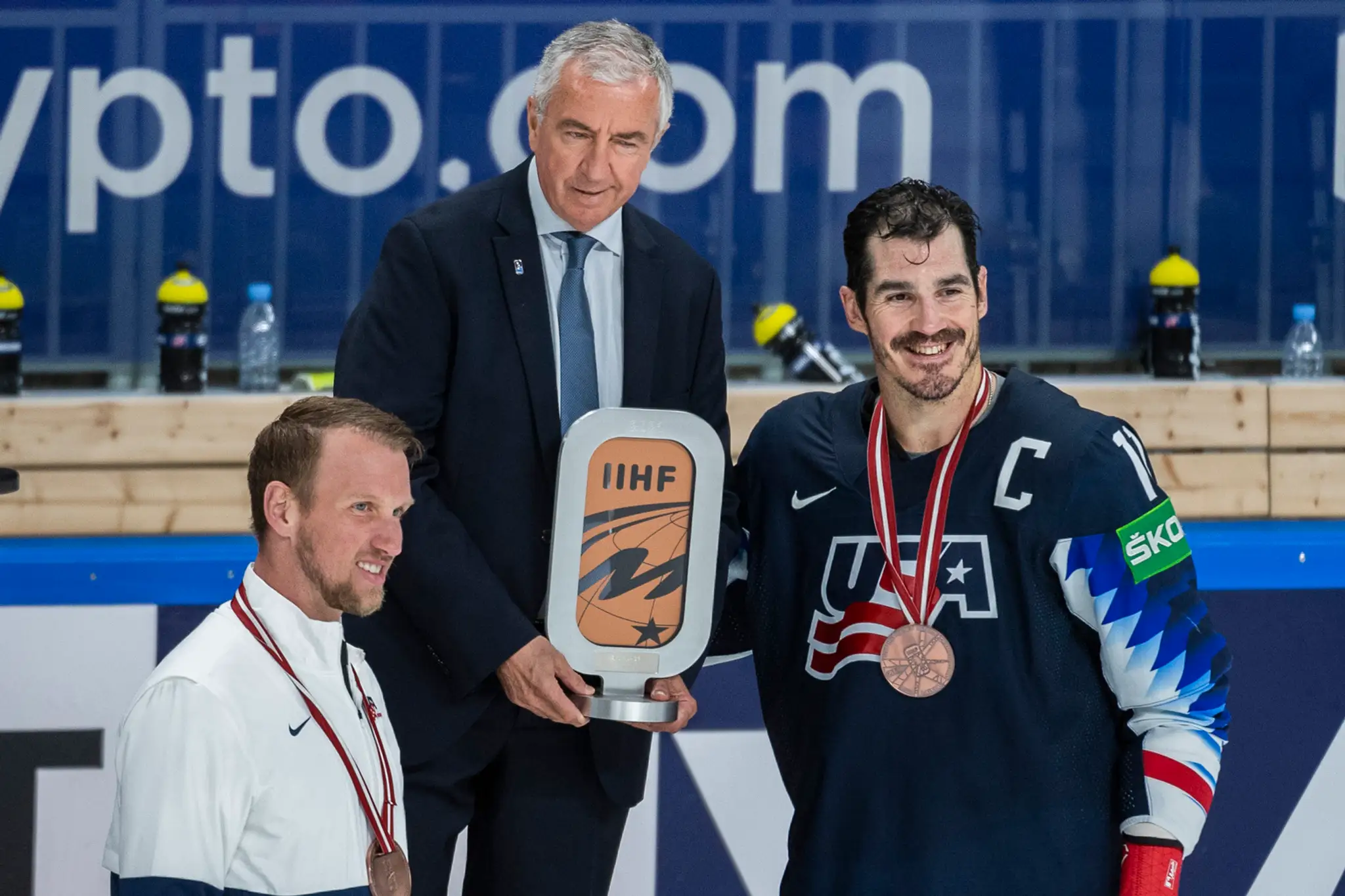 Prezident IIHF Luc Tardif odovzdáva ocenenie hráčom USA.