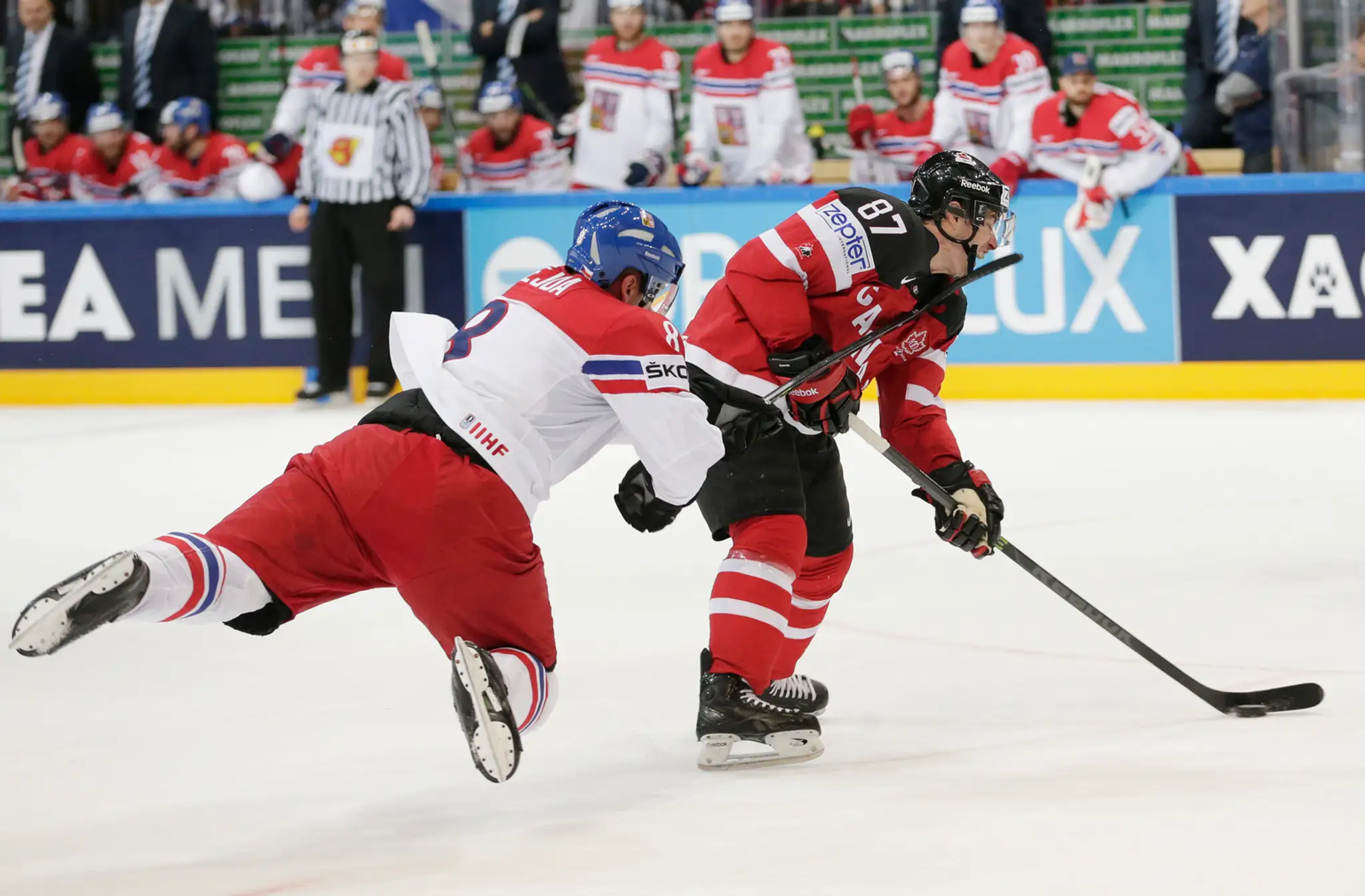 Kanadský hráč Sidney Crosby (vpravo) dostáva úder hokejkou do tváre od Čecha Jana Hejdu