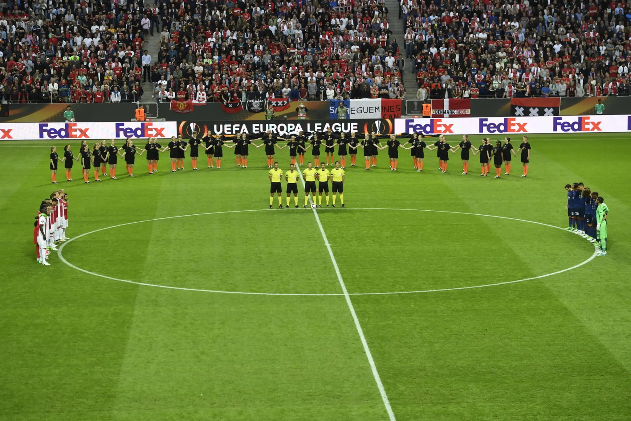 Hráči ManUtd (vpravo) a Ajaxu si minútou ticha uctievajú pamiatku obetí teroristického útoku pred finále EL.