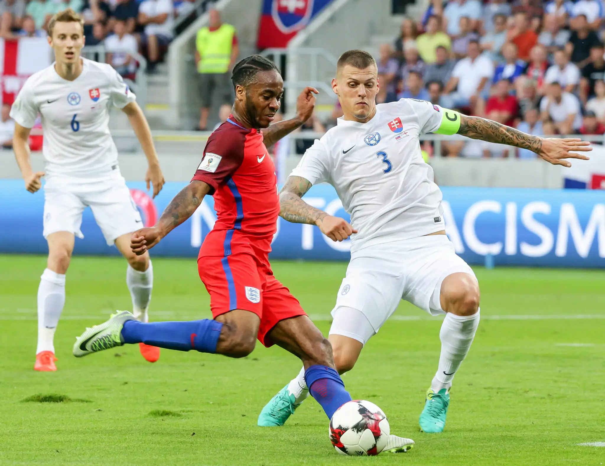 Hviezda anglického tímu Raheem Sterling (v červenom) proti nášmu kapitánovi Martinovi Škrtelovi v dueli kvalifikácie MS 2018.