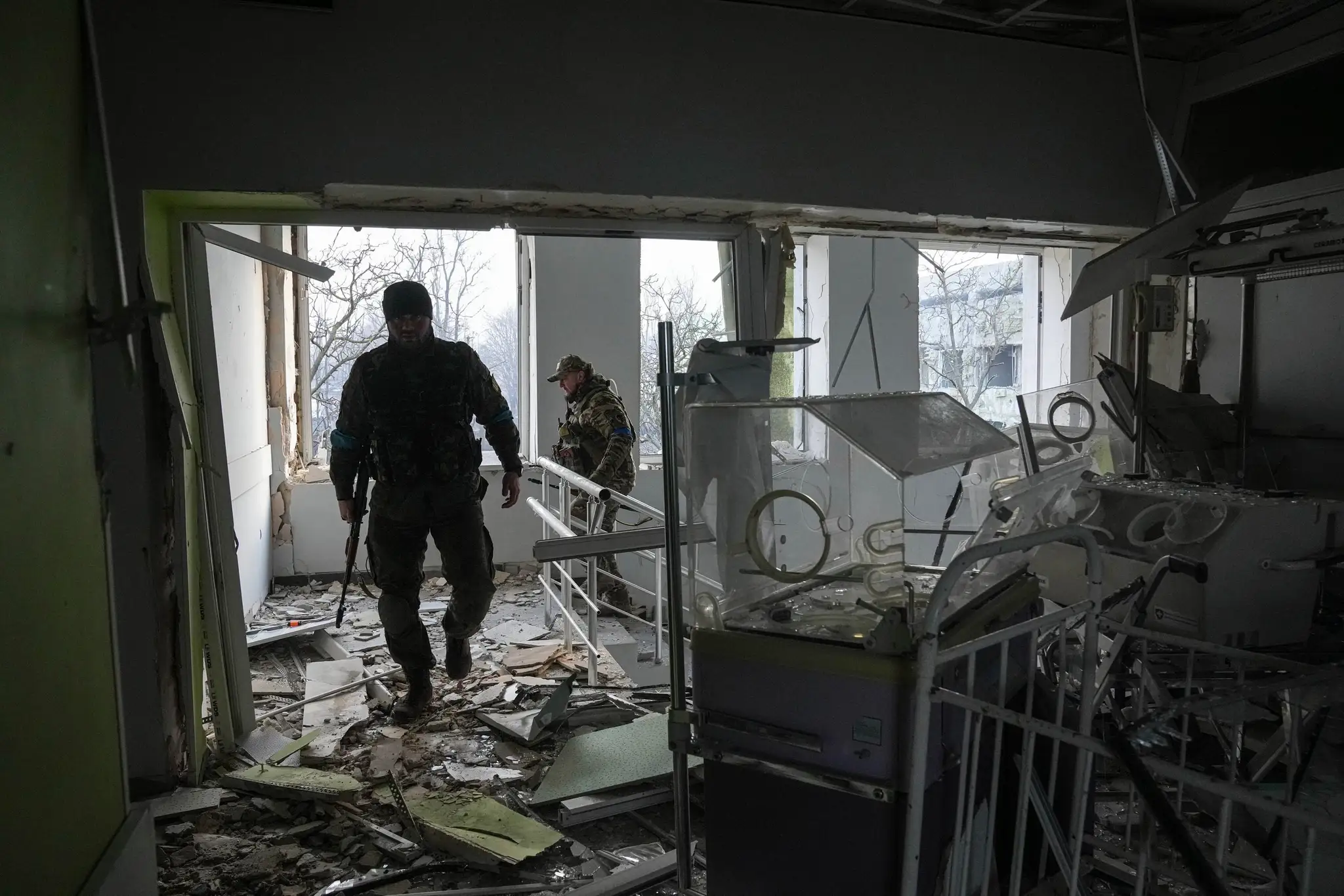Ukrajinskí vojaci pomáhajú v bombami zničenej pôrodnici v Mariupole.