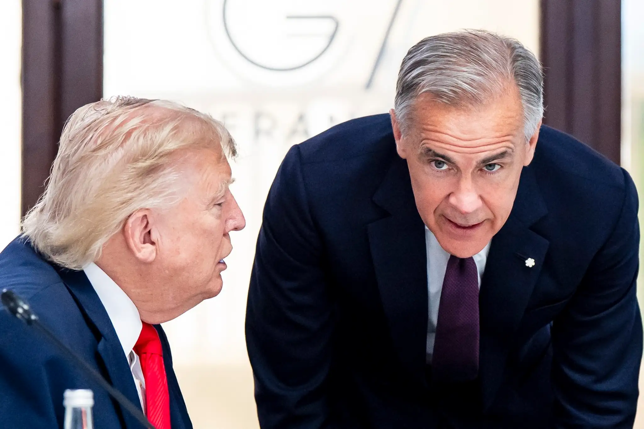 Americký prezident Donald Trump a kanadský premiér Mark Carney sa rozprávajú počas samitu G7.