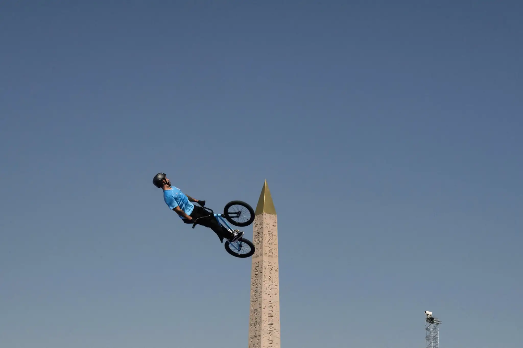 Torres akoby na bicykli vyliezol na bok obelisku na námestí Place de la Concorde