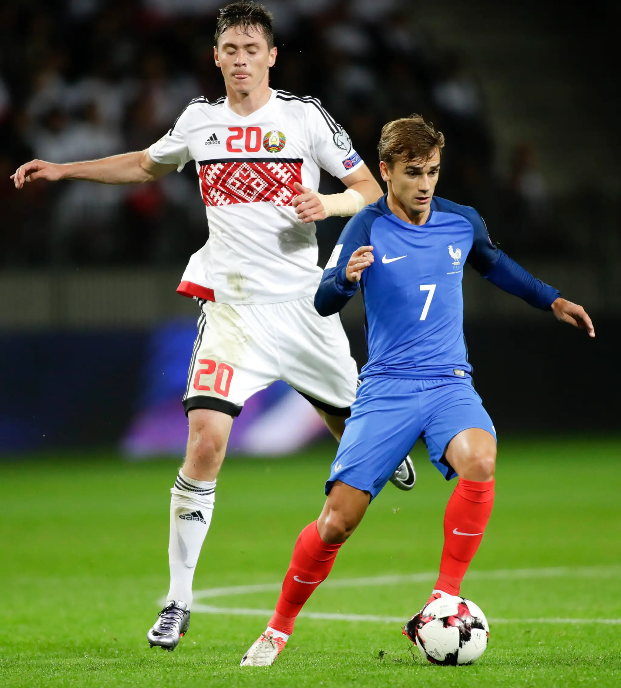 Ostrostrelec Francúzska Antoine Griezmann (v modrom) v súboji s Bielorusom Nikolajom Signevičom v kvalifikácii MS 2018.