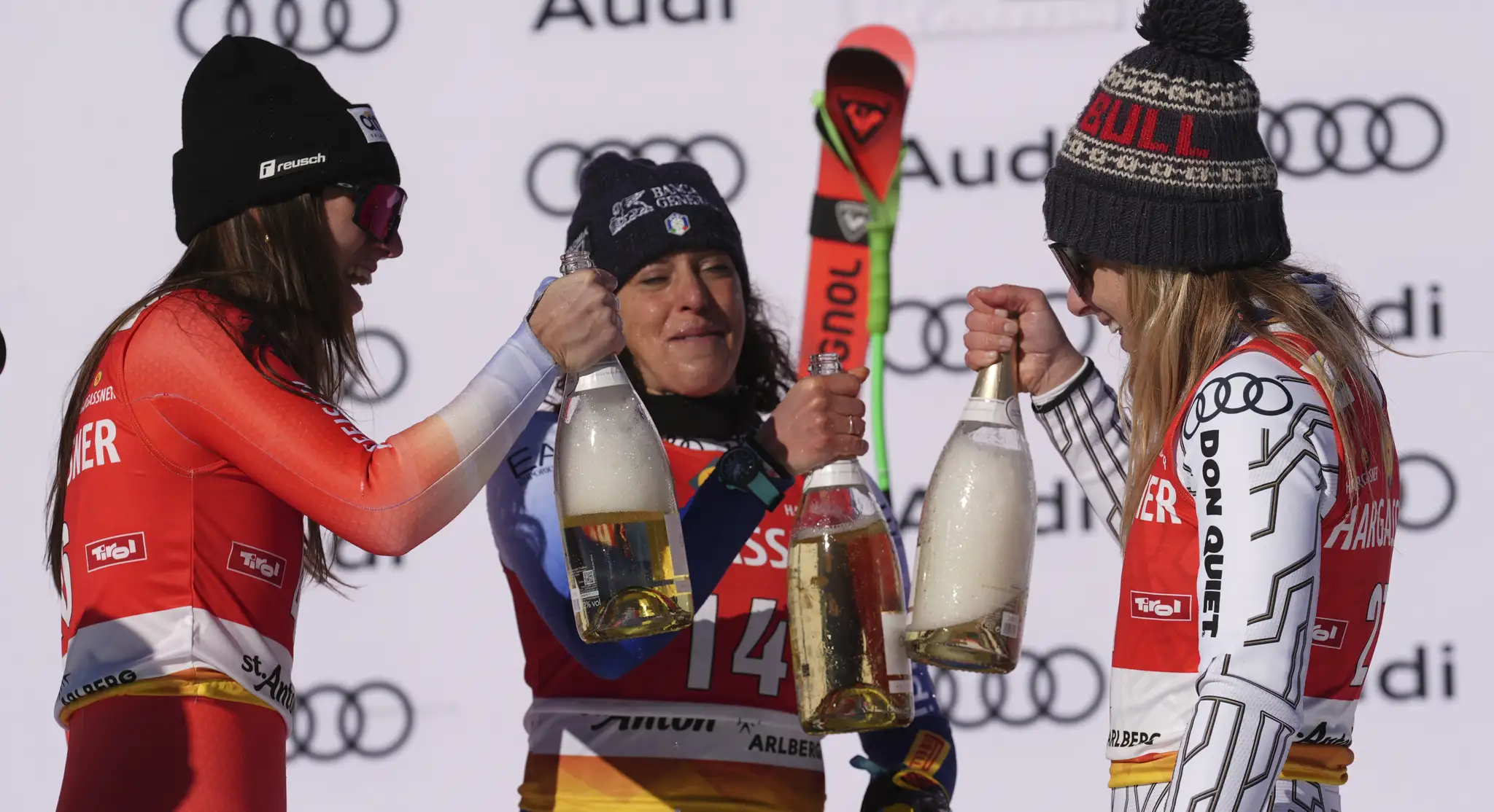 Talianka Federica Brignoneová (uprostred) pózuje so šampanským na pódiu po triumfe v zjazde Svetového pohára alpských lyžiarok v rakúskom stredisku St. Anton