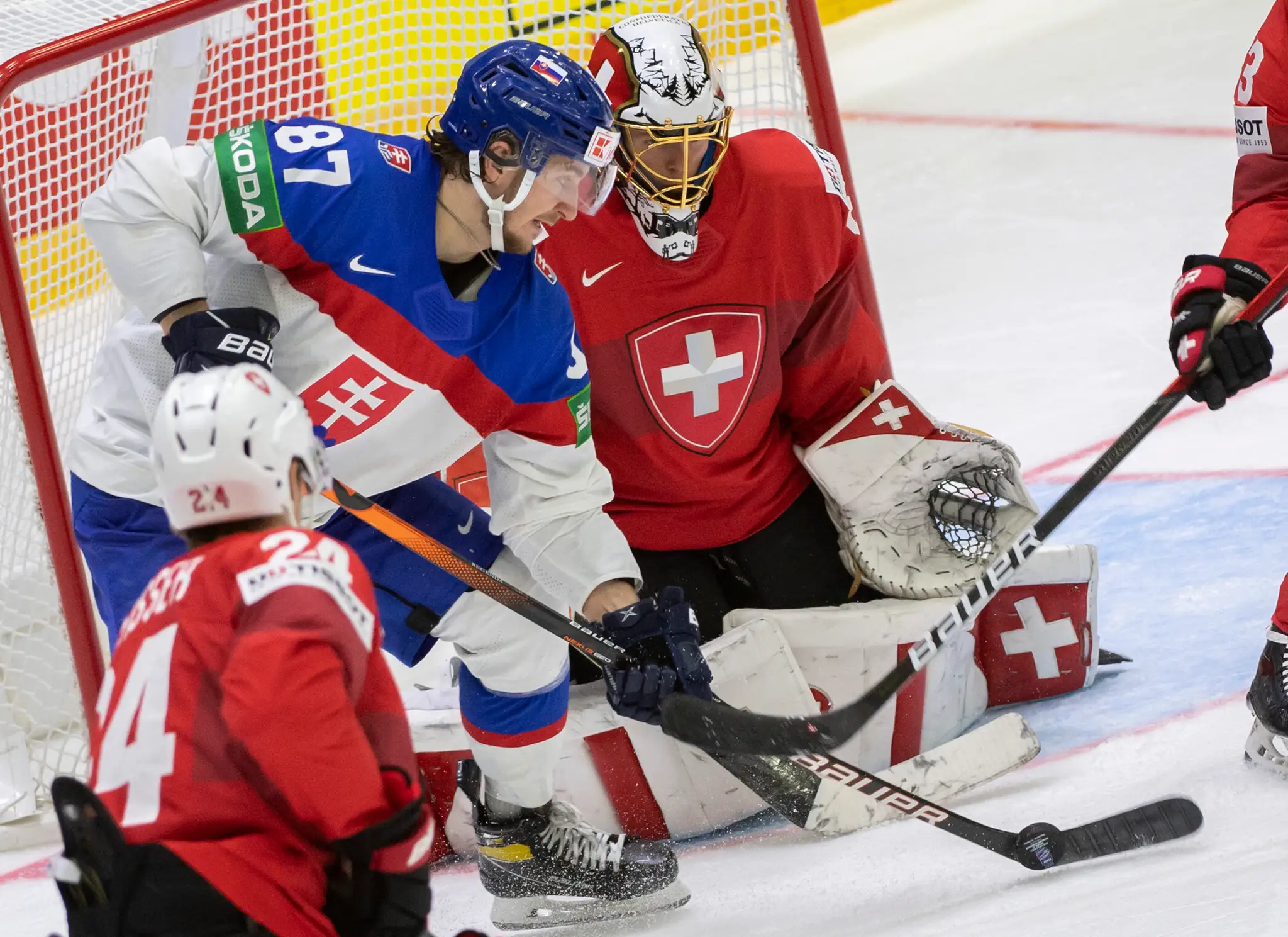 Na snímke vľavo Pavol Regenda (Slovensko) a vpravo brankár Leandro Genoni (Švajčiarsko).