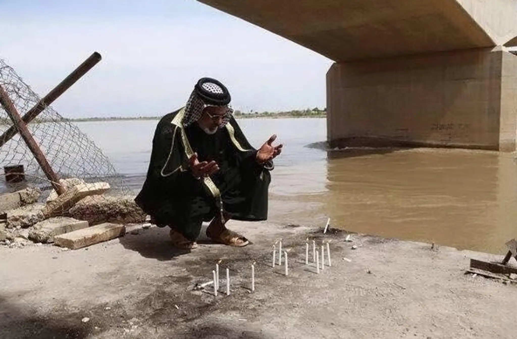 Muž sa modlí pri masovom hrobe v irackom meste Tikrit