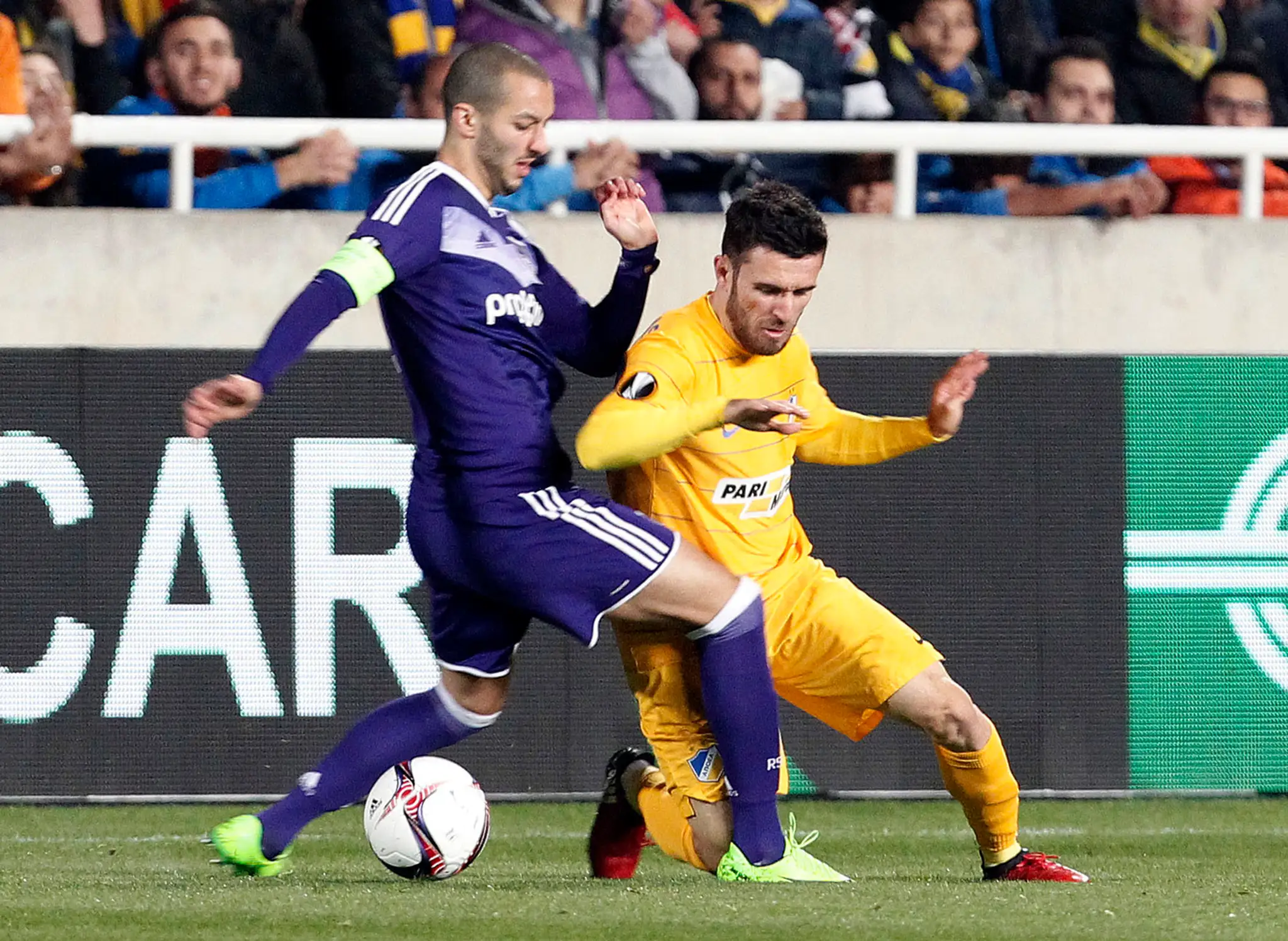 Yiannis Gianniotas (vpravo) z APOELu bojuje o loptu s Bramom Nuytinckom z Anderlechtu v osemfinále EL.