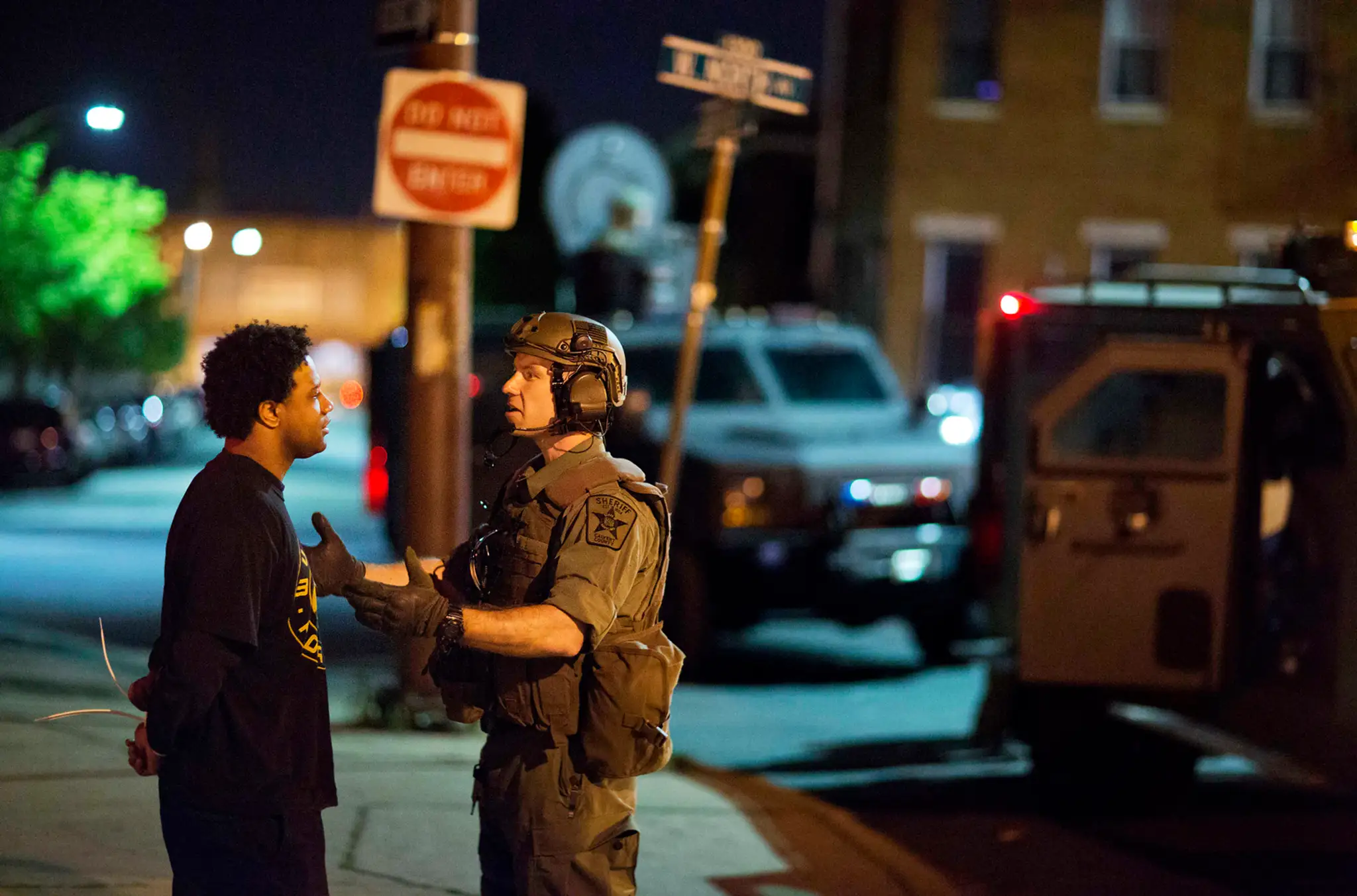 Policajt a zadržaný muž po výtržnostiach v Baltimore po zákaze vychádzania. 29. apríla