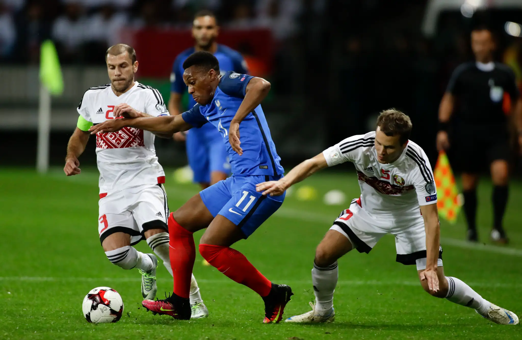 Francúzska hviezdička Anthony Martial (v modrom) v snahe získať loptu pred bieloruským Timofejom Kalačevom v kvalifikácii MS 201
