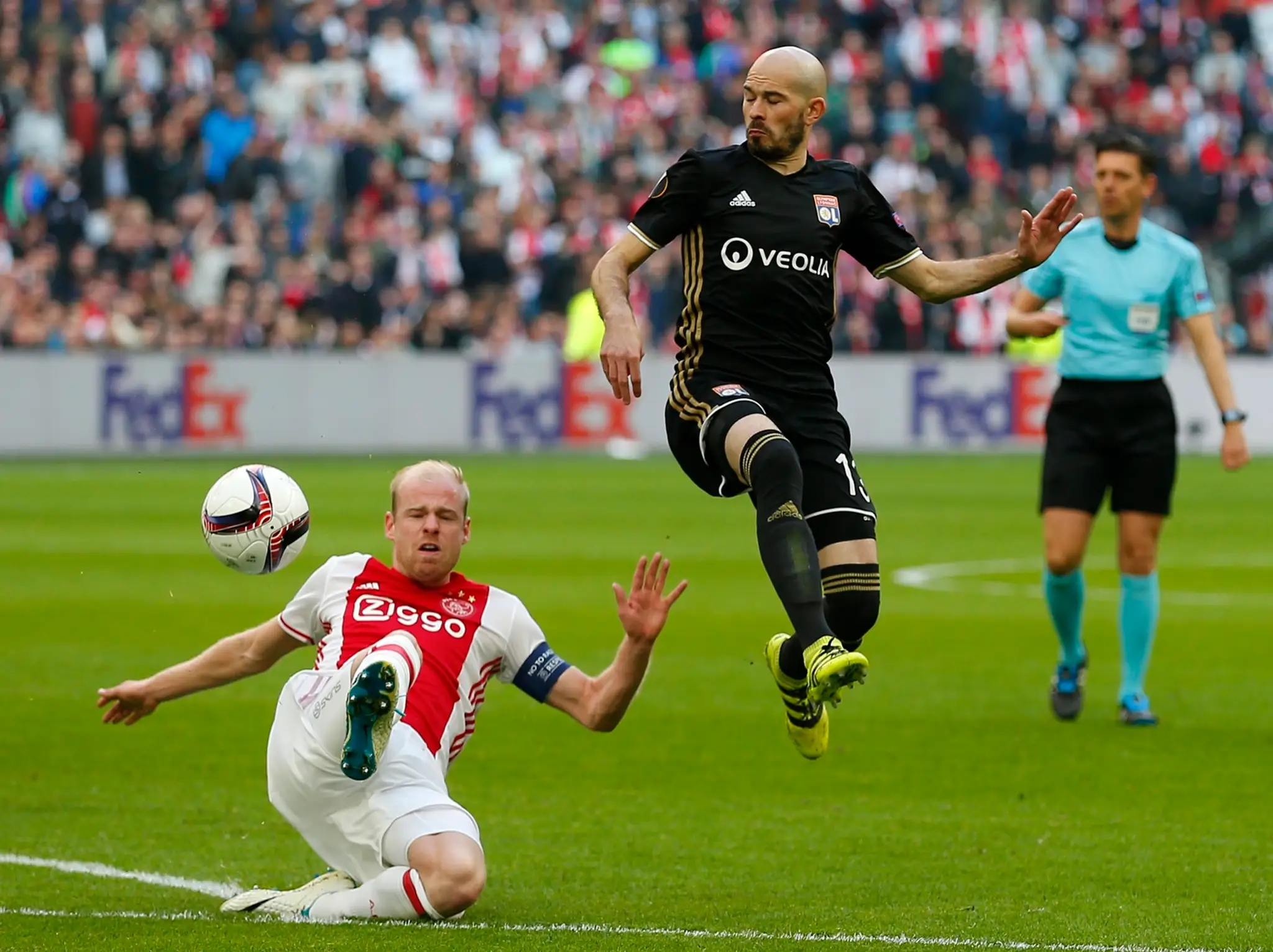 Christophe Jallet (vpravo) z Lyonu sa v semifinále EL snaží uniknúť kapitánovi Ajaxu Davymu Klaassenovi.