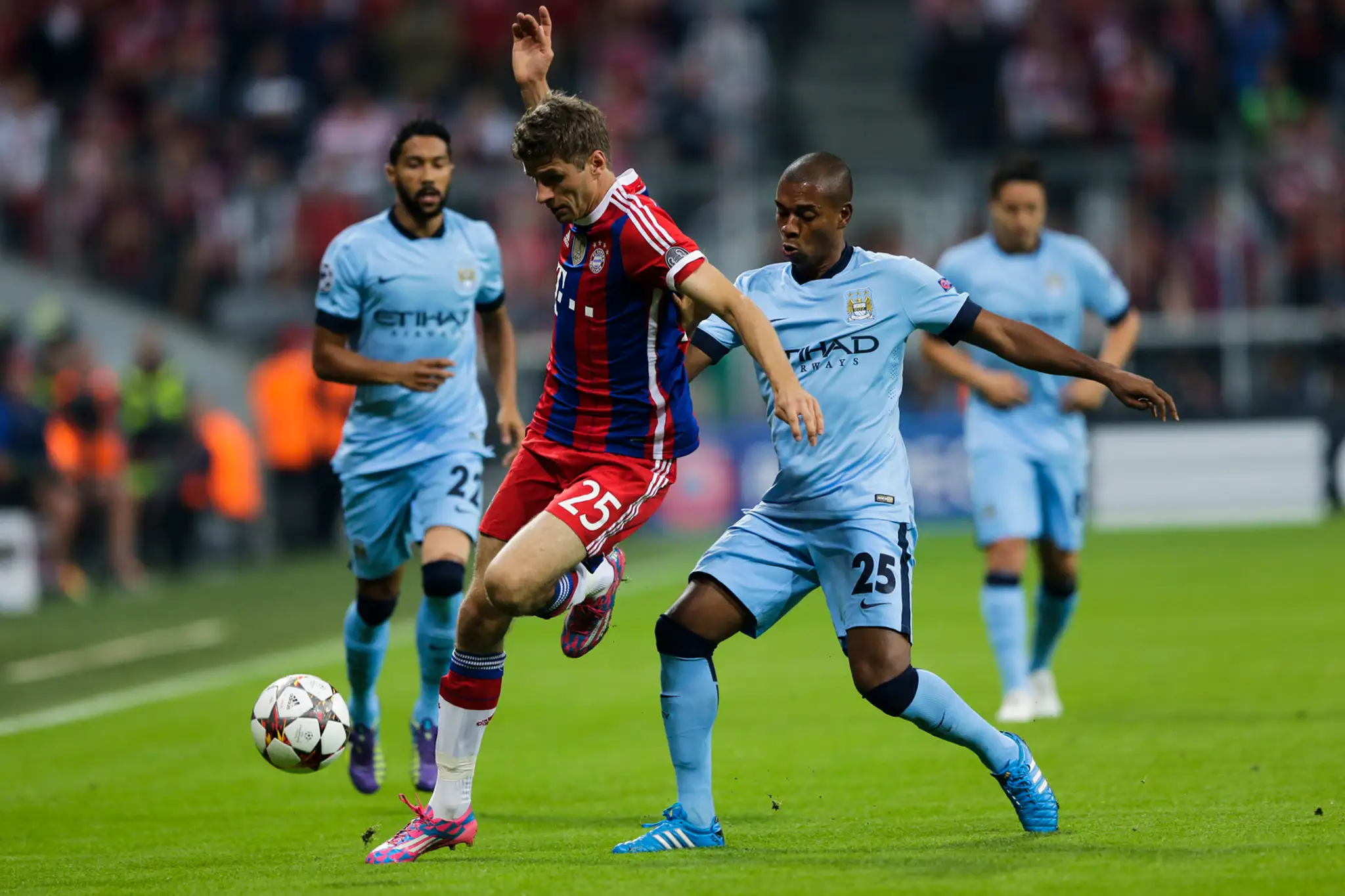 Hráč Bayernu Thomas Müller (vľavo) a hráč Manchestru Fernandinho (vpravo) bojujú o loptu v zápase Ligy majstrov skupiny E