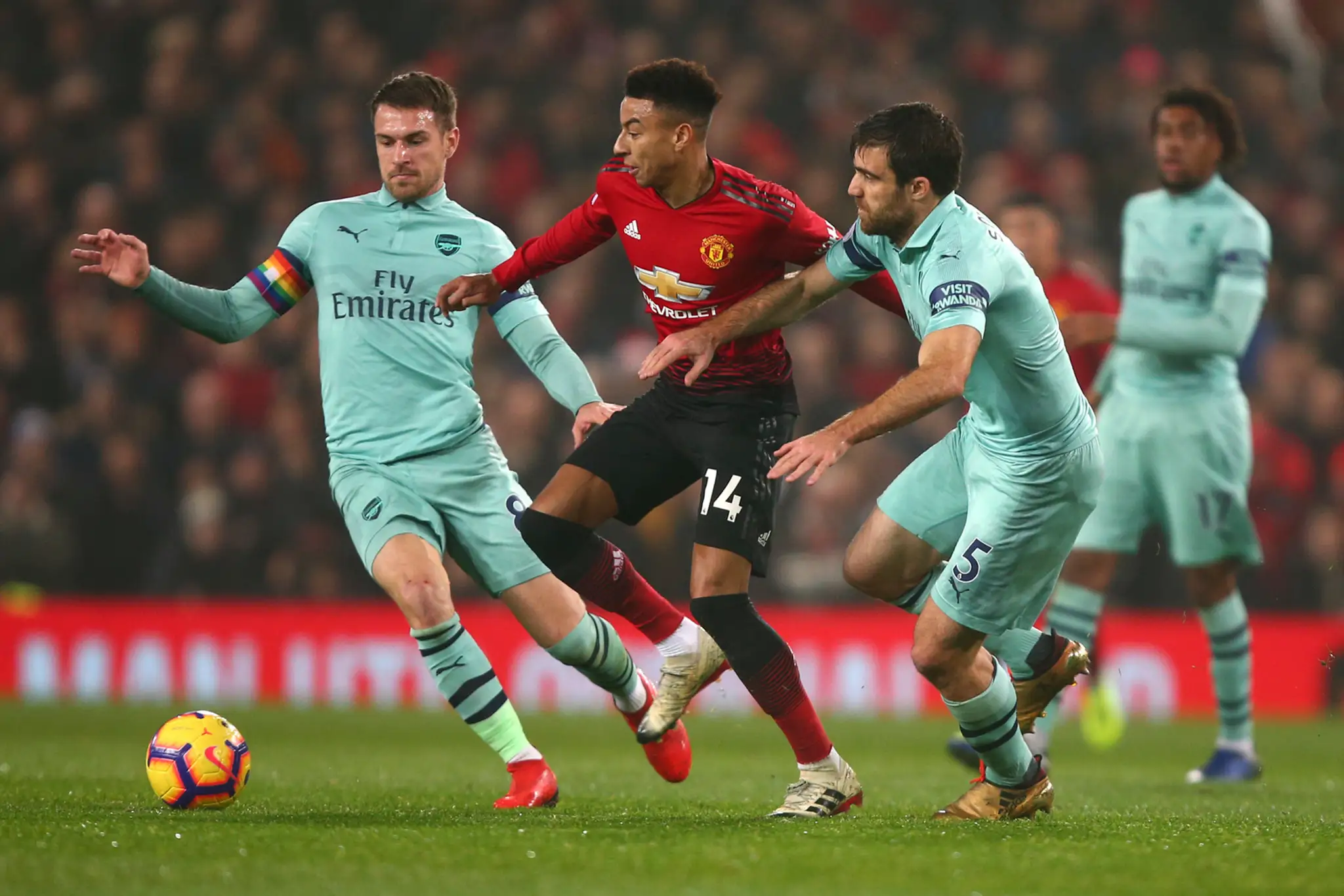Jesse Lingard (v strede) z Manchesteru United v obklopení vľavo Aarona Ramseyho a Sokratisa Papastathopoulosa z Arsenalu.