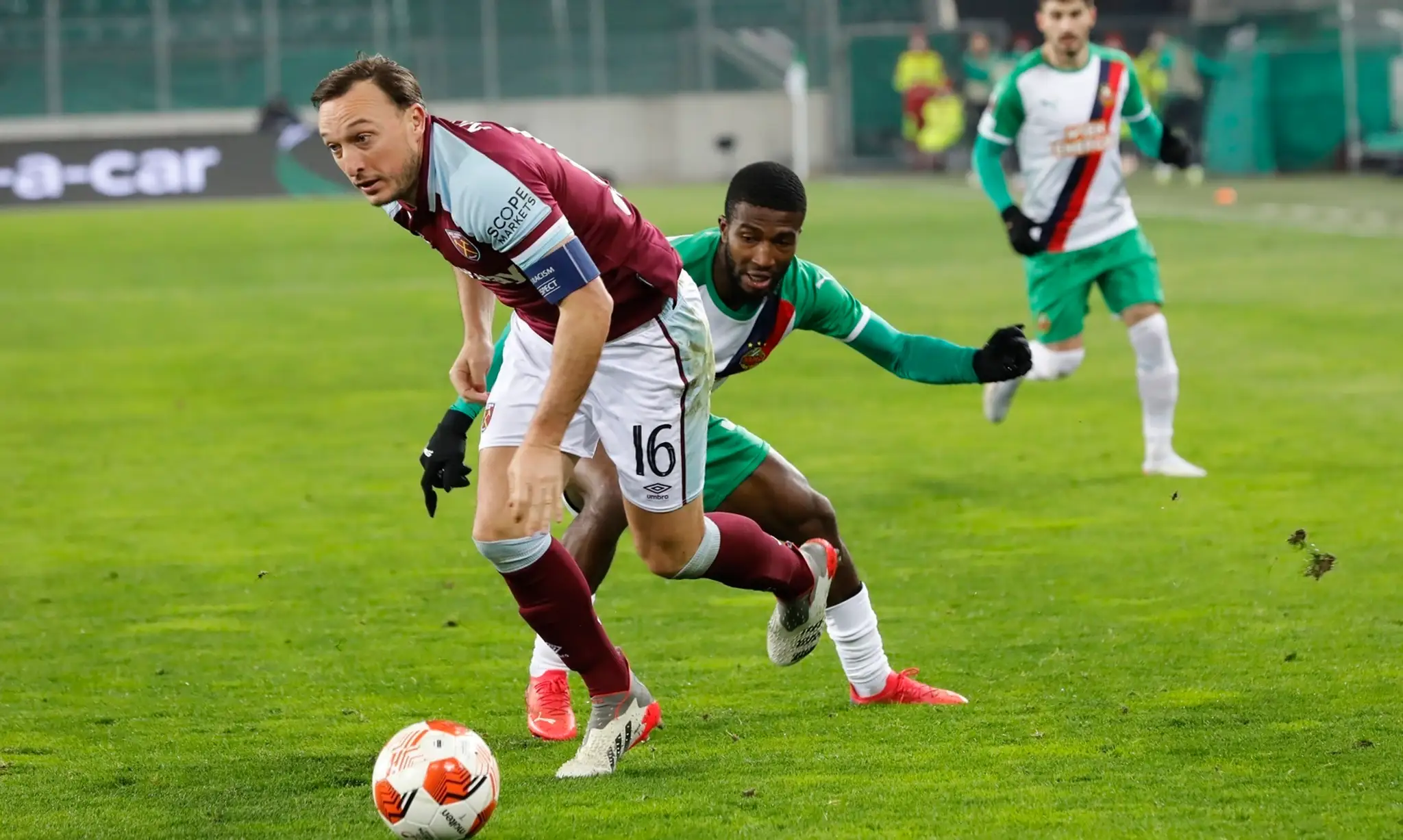 Mark Noble (West Ham) v súboji o loptu s Kelvinom Arasem z Rapidu Viedeň.