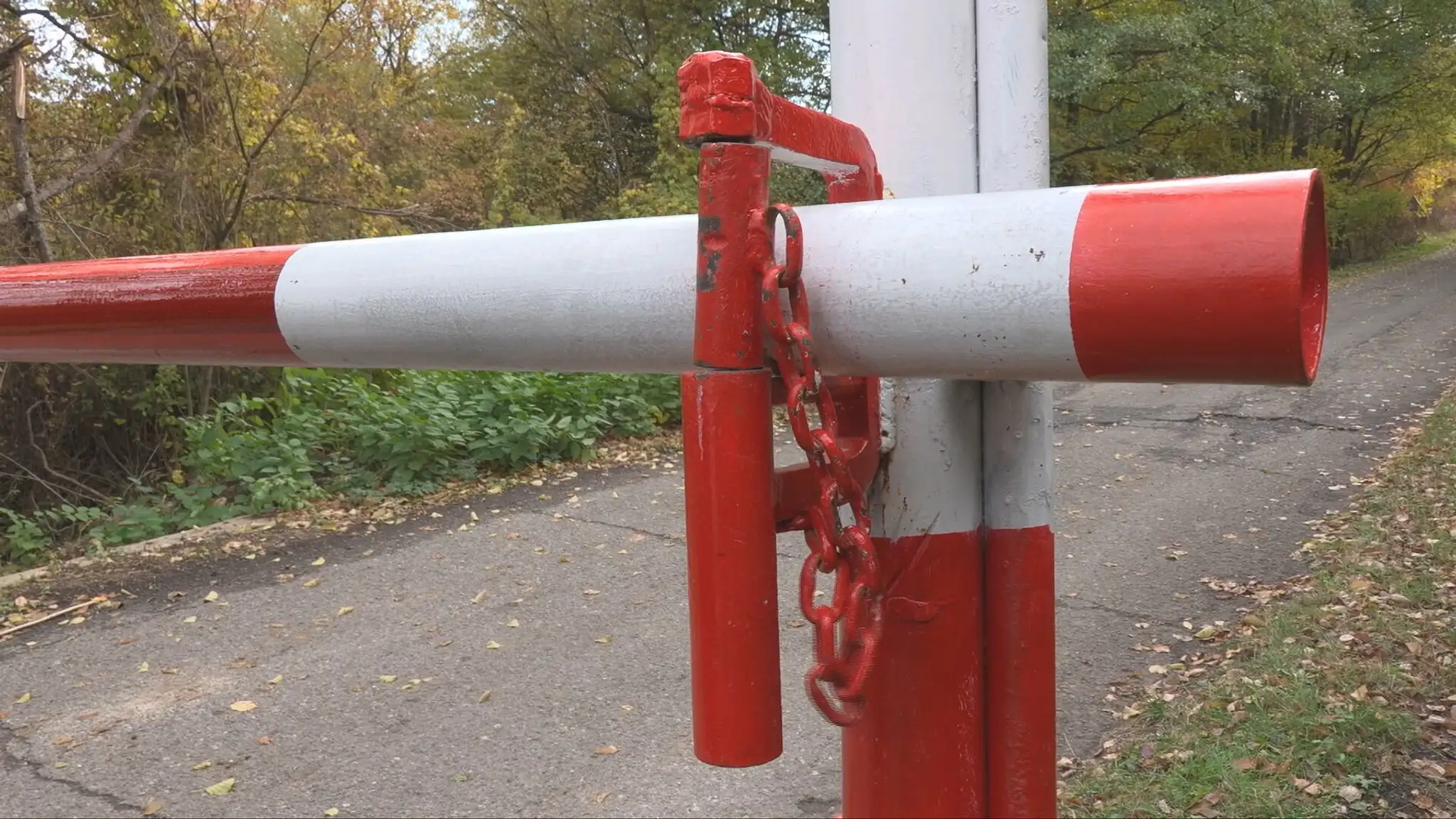 Závora so zámkom komplikuje prístup k pozemkom.
