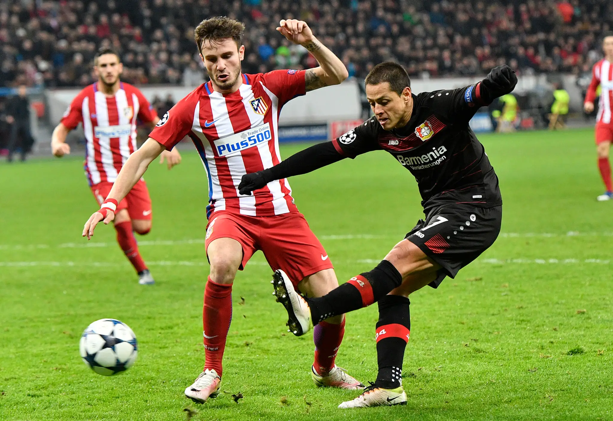Chicharito (vpravo) z Leverkusenu páli na bránku Atlética v osemfinále LM, snaži sa ho zastaviť Saúl Níguez.