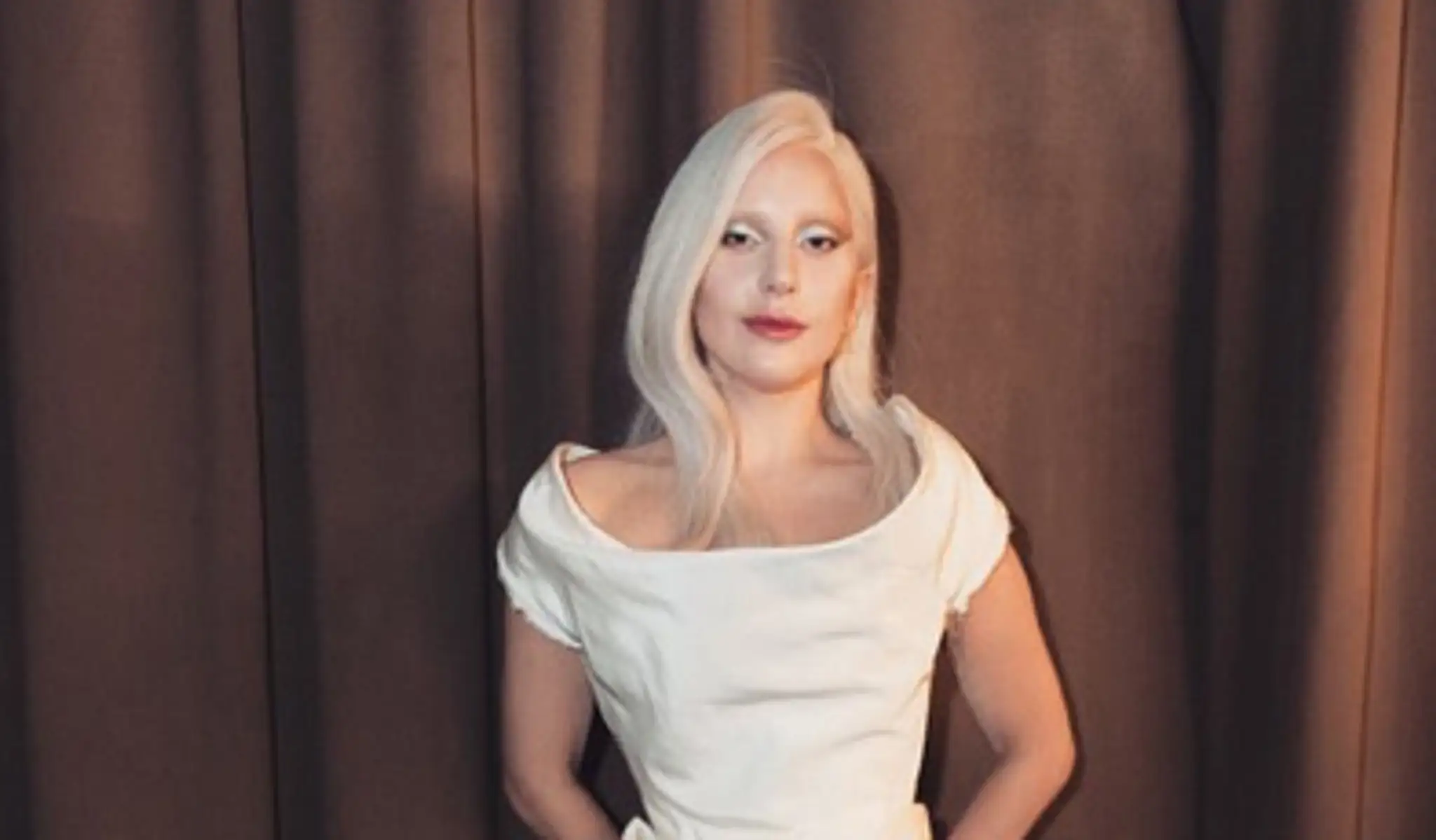 Lady Gaga ako nežná žena v bielych šatách.