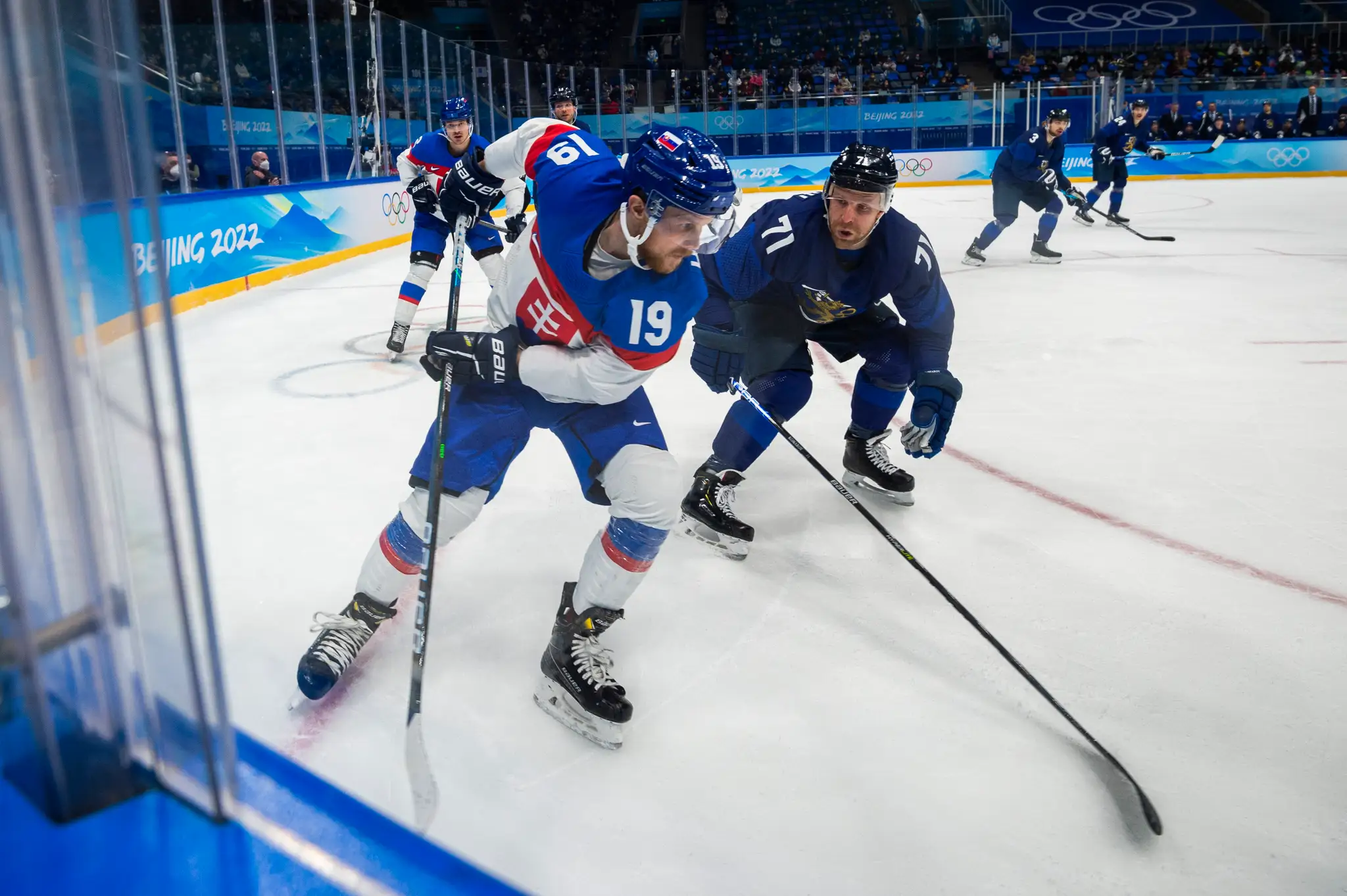 Zľava hokejista Slovenska Michal Krištof a hráč Fínska Leo Komarov v semifinále ZOH 2022.